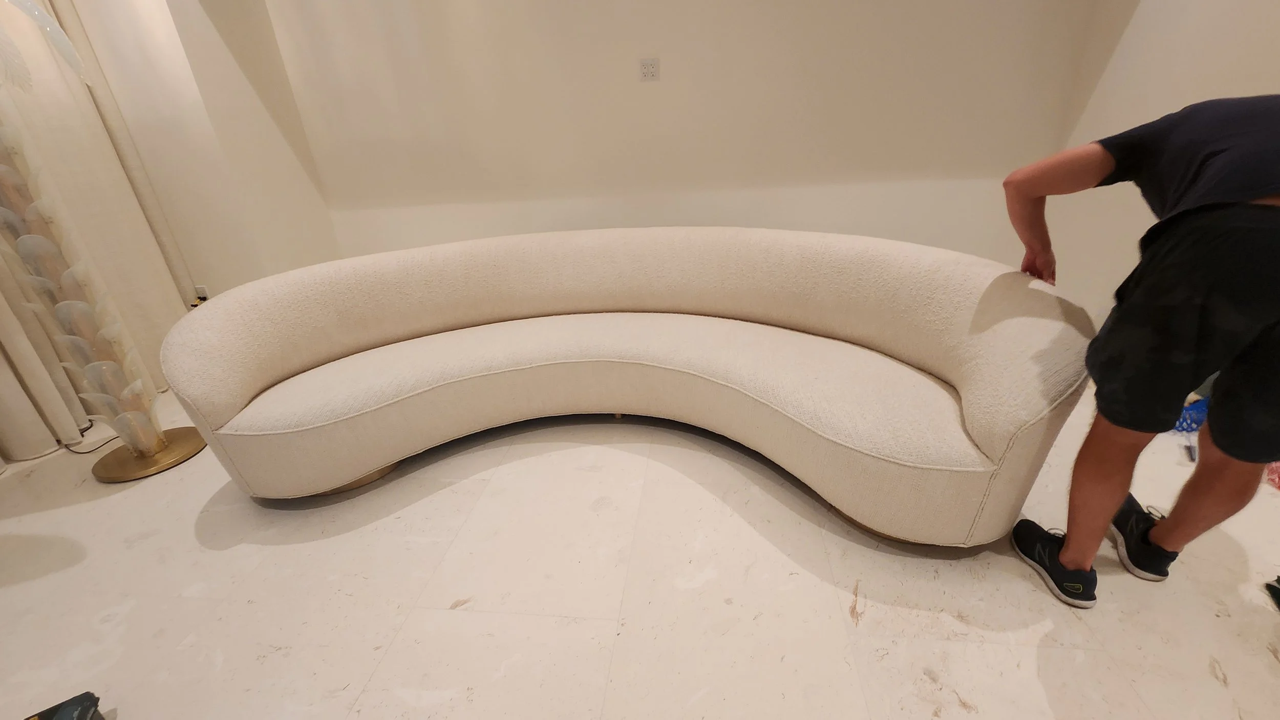 Large curved sofa installation inside a luxury residence