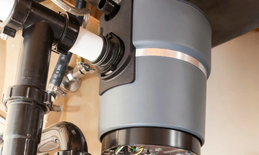 Close-up of a telescope focusing mechanism with black and gray components, metal piping, and electrical wires visible at the bottom.