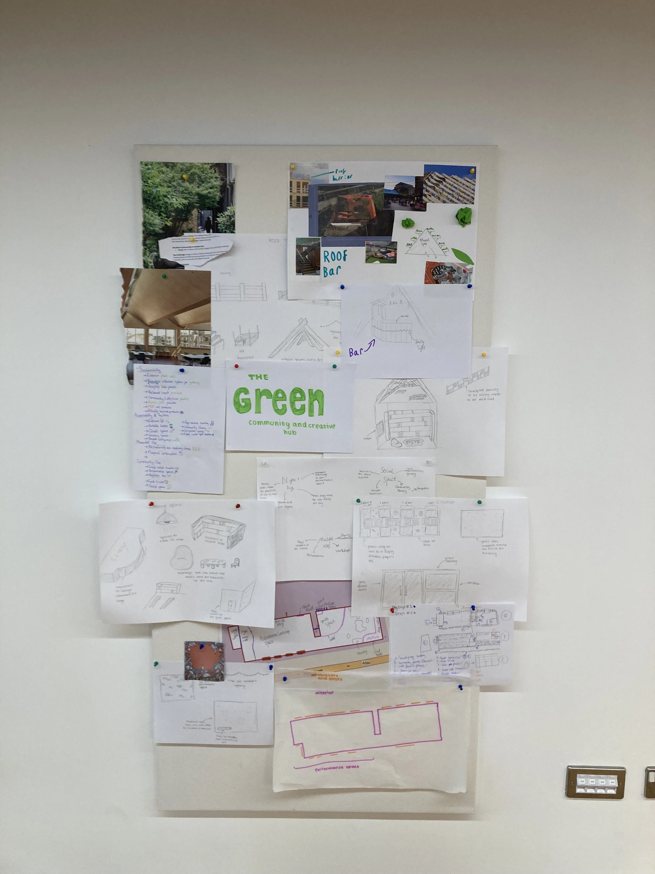 Mountains with snow-capped peaks in the background and a modern building on a grassy hillside in the foreground.