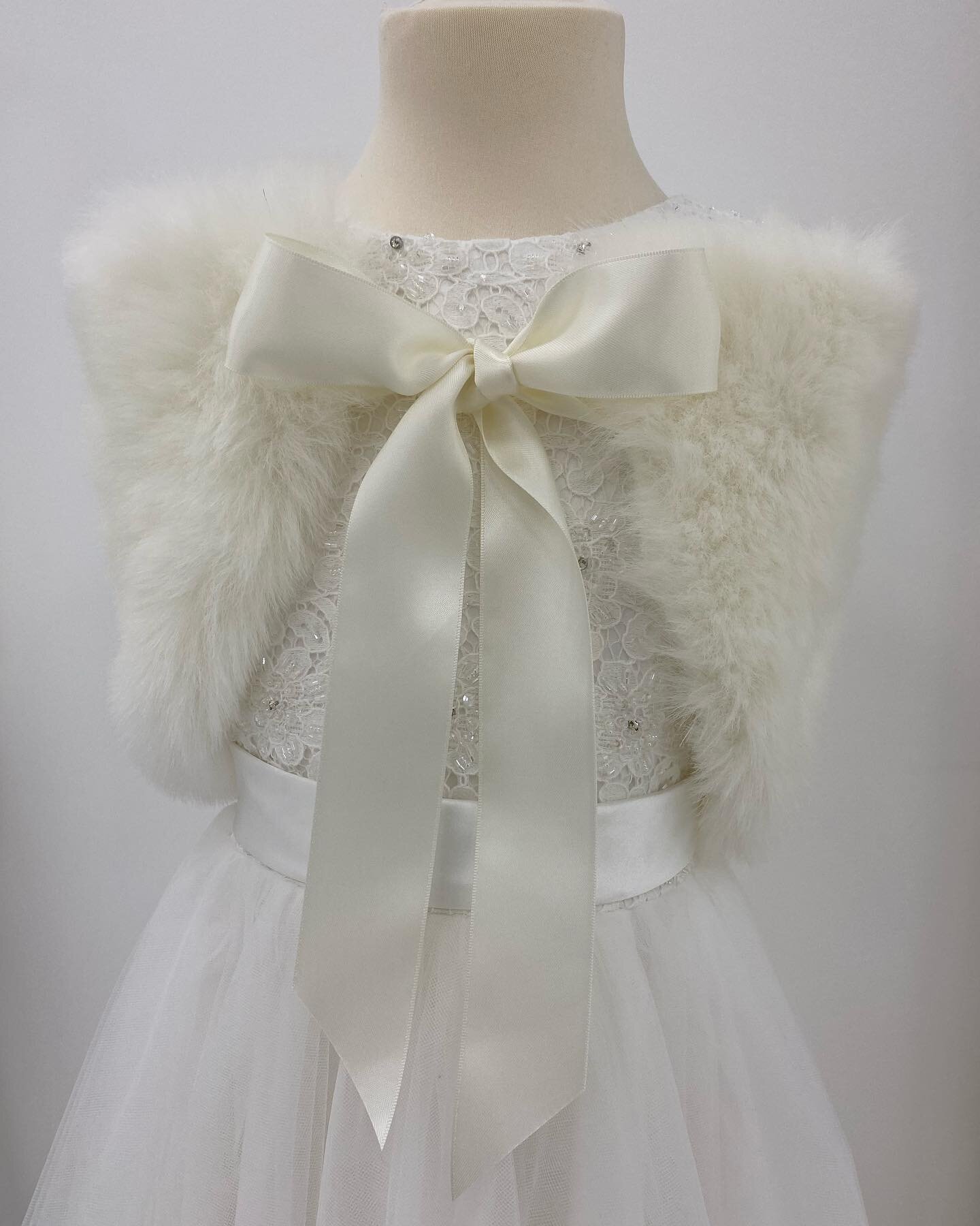 A faux fur wrap fastened with a luxurious satin ribbon. Available in Ivory, Charcoal or Honey. Small is suitable for approximately ages 2-5years, measuring 53cm wide and 22cm deep. Medium, for age 5-8years, measuring 60cm wide and 23cm deep, and larg