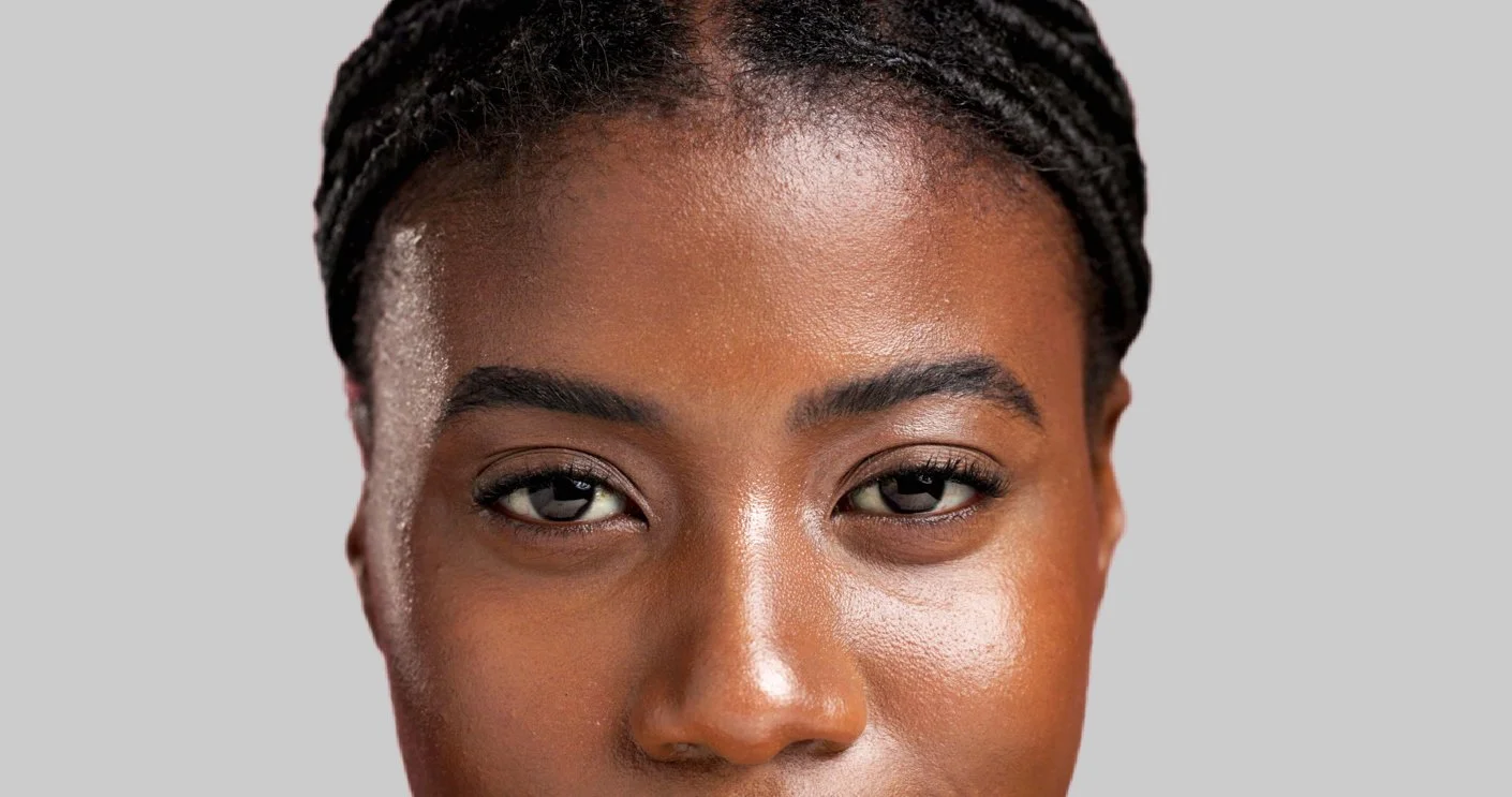 A close-up image of a Black woman's face, highlighting the expertly shaped and tinted eyebrows, representative of the work performed by professionals at Flirt Custom Lash Studio Toronto.