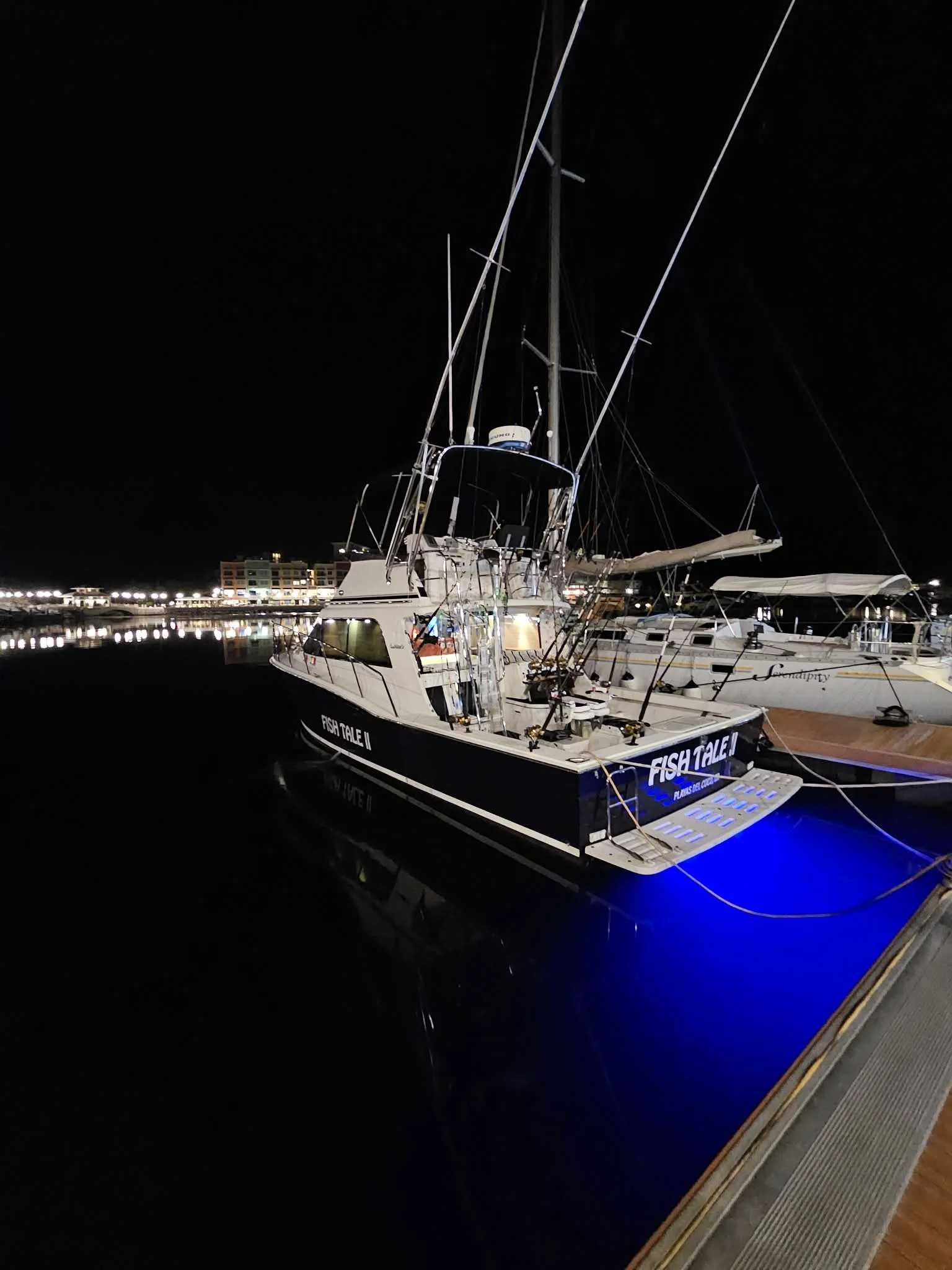 Fish Tale 2 boat docked at the Marina Flamingo at night in Guanacaste Costa Rica with illuminated deck and full fishing setup on display