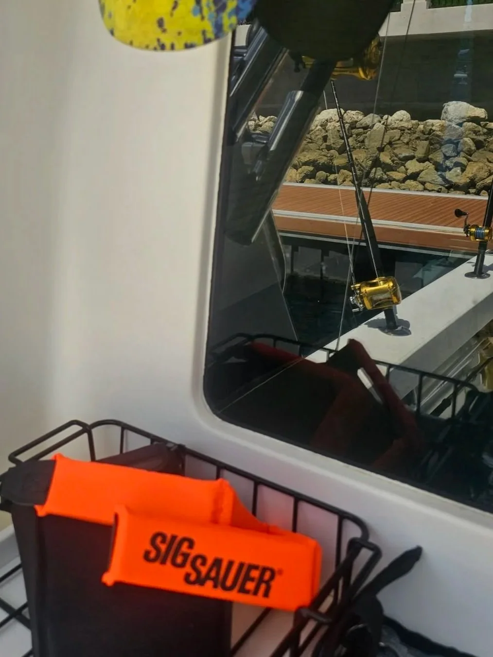 Sig Sauer Gyro Stabilized optics and Fishing rods and reels inside Fish Tale 2 cabin with safety gear prepared for an offshore fishing charter in Costa Rica