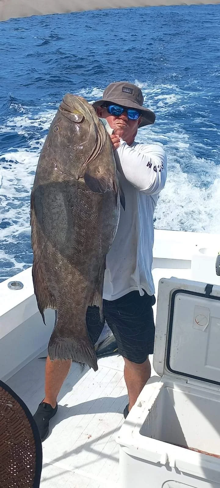 Angler holding a large Grouper aboard Fish Tale 2 during offshore fishing charter in Guanacaste Costa Rica
