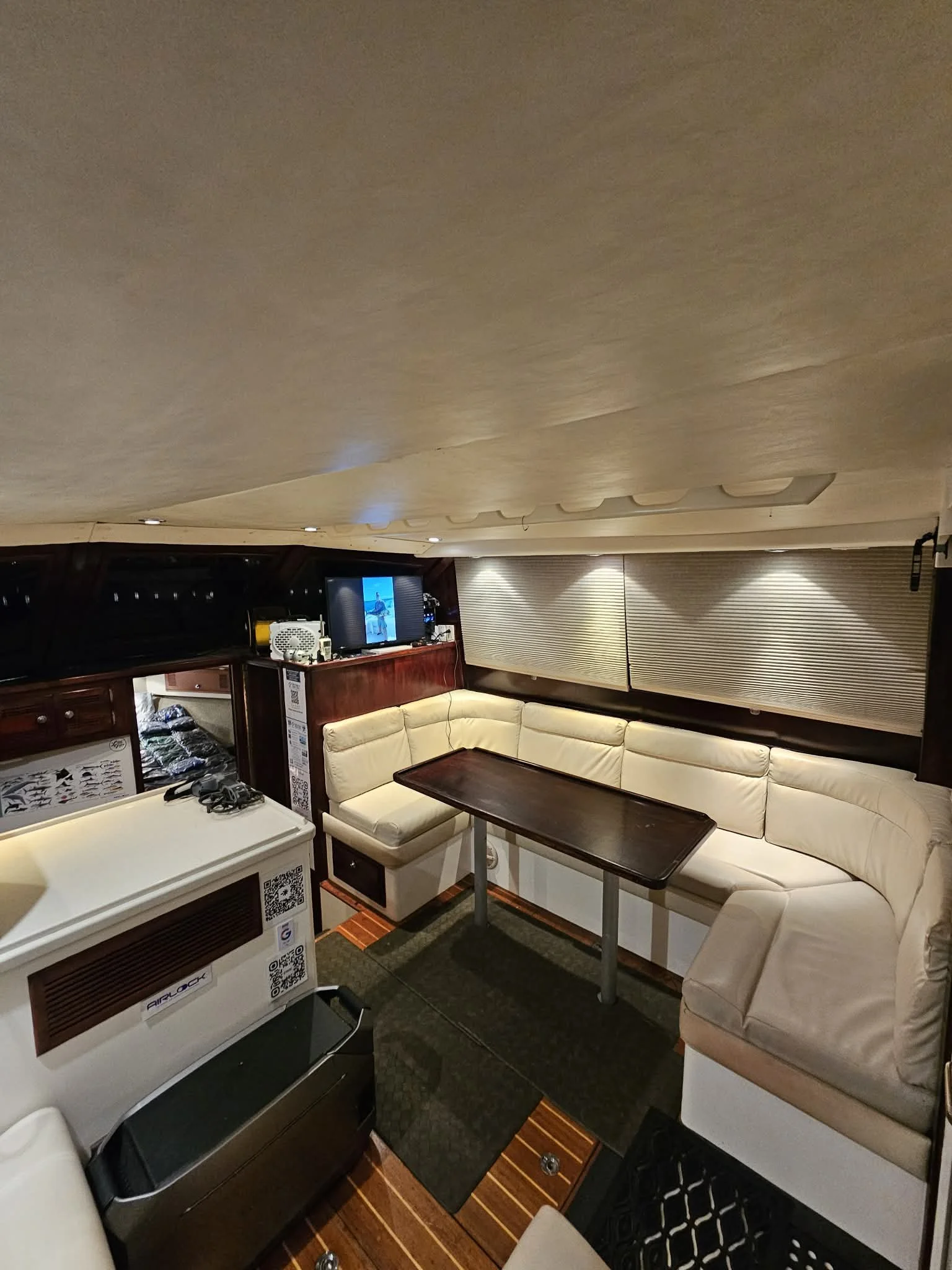 Interior of Fish Tale 2 with seating, table, and onboard entertainment system during private fishing charter in Costa Rica, Guanacaste