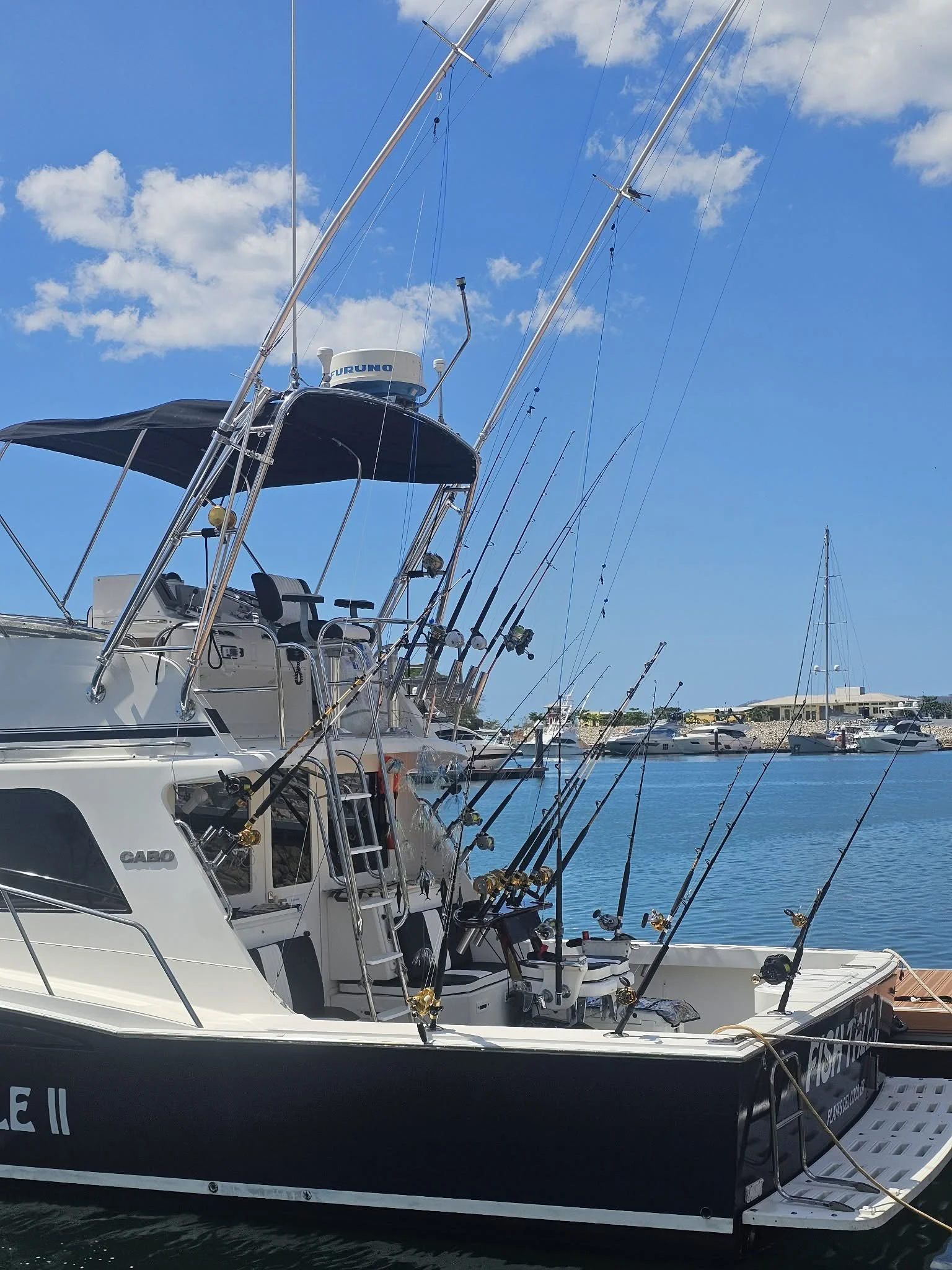 Fish Tale 2 fishing charter boat docked at Marina Flamingo in Guanacaste Costa Rica with rods set for offshore fishing under blue skies