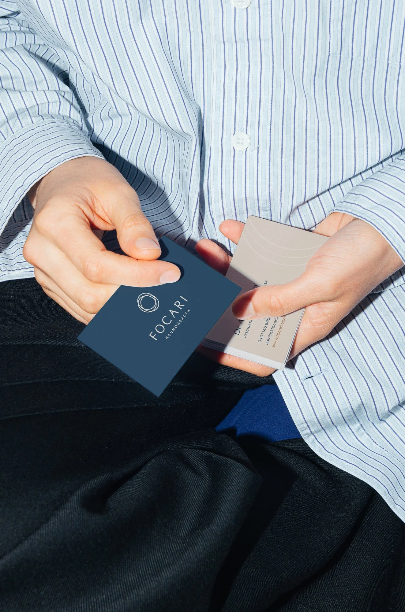 Close up of hands holding business cards that read Focari Neurohealth.