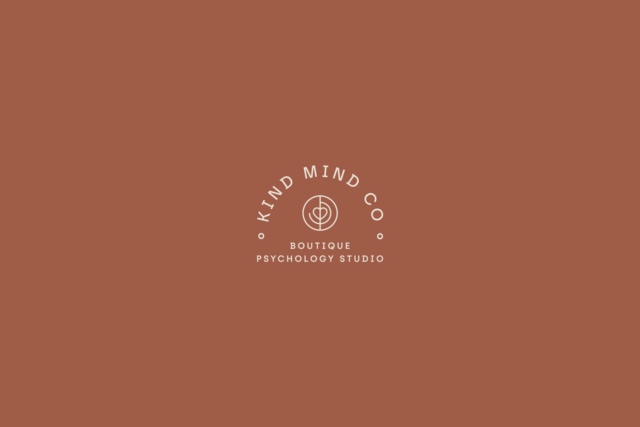 Logo for Kind Mind Co, a boutique psychology studio, featuring a circular icon with a heart and line design, on a brown background.
