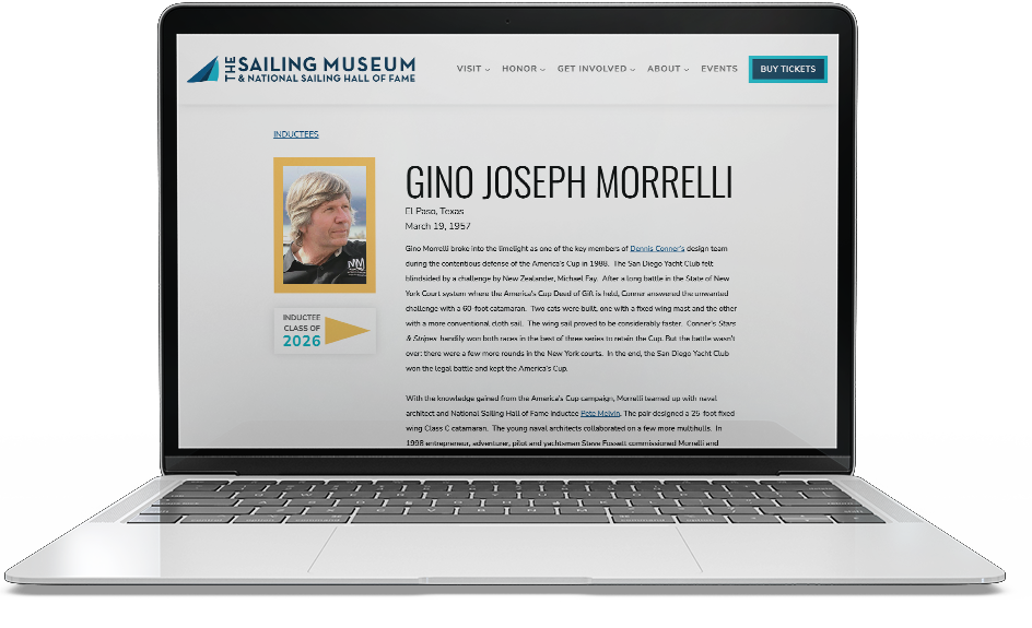 Laptop displaying a webpage for the Sailing Museum and National Sailing Hall of Fame, featuring inductee Gino Joseph Morrelli, with a photo of him, his biography, and navigation menu.