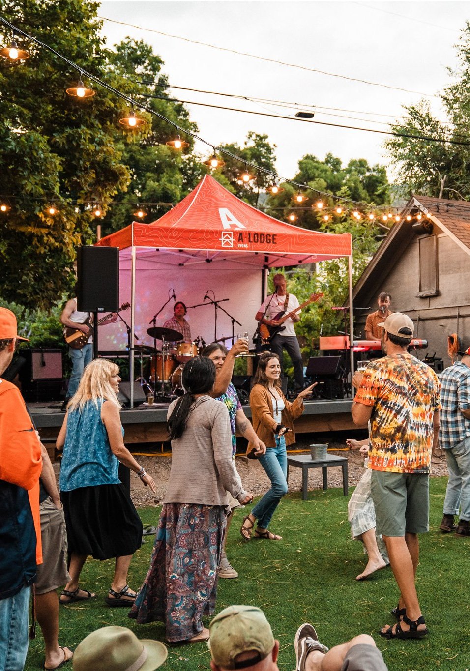 Live music at The Rock Garden outdoor beer garden in Lyons Colorado with crowd dancing and band performing