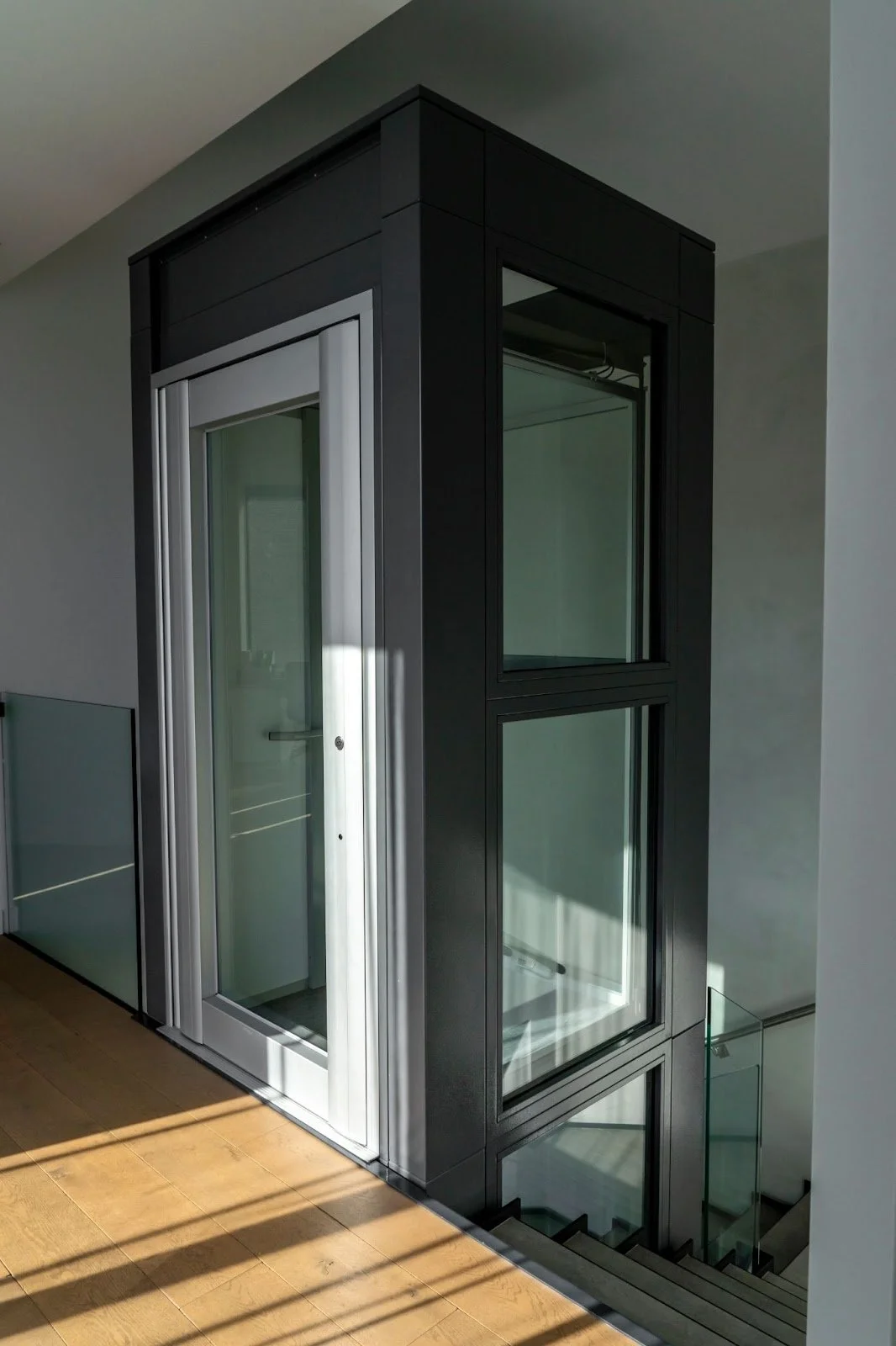 A sleek glass elevator in a contemporary home, providing mobility and an alternative to stairs