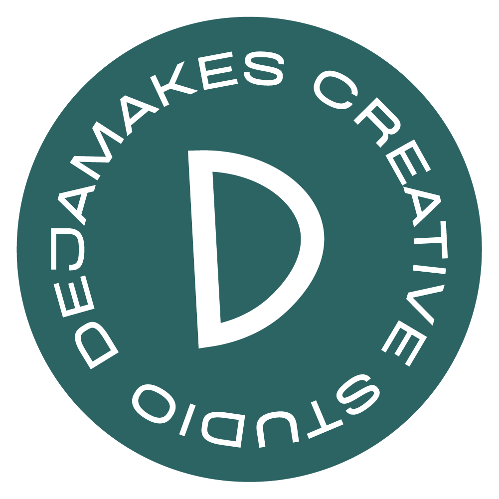 Circular stamp with a large letter D in the center and the phrase "Deja Makes Creative Studio" around the perimeter.