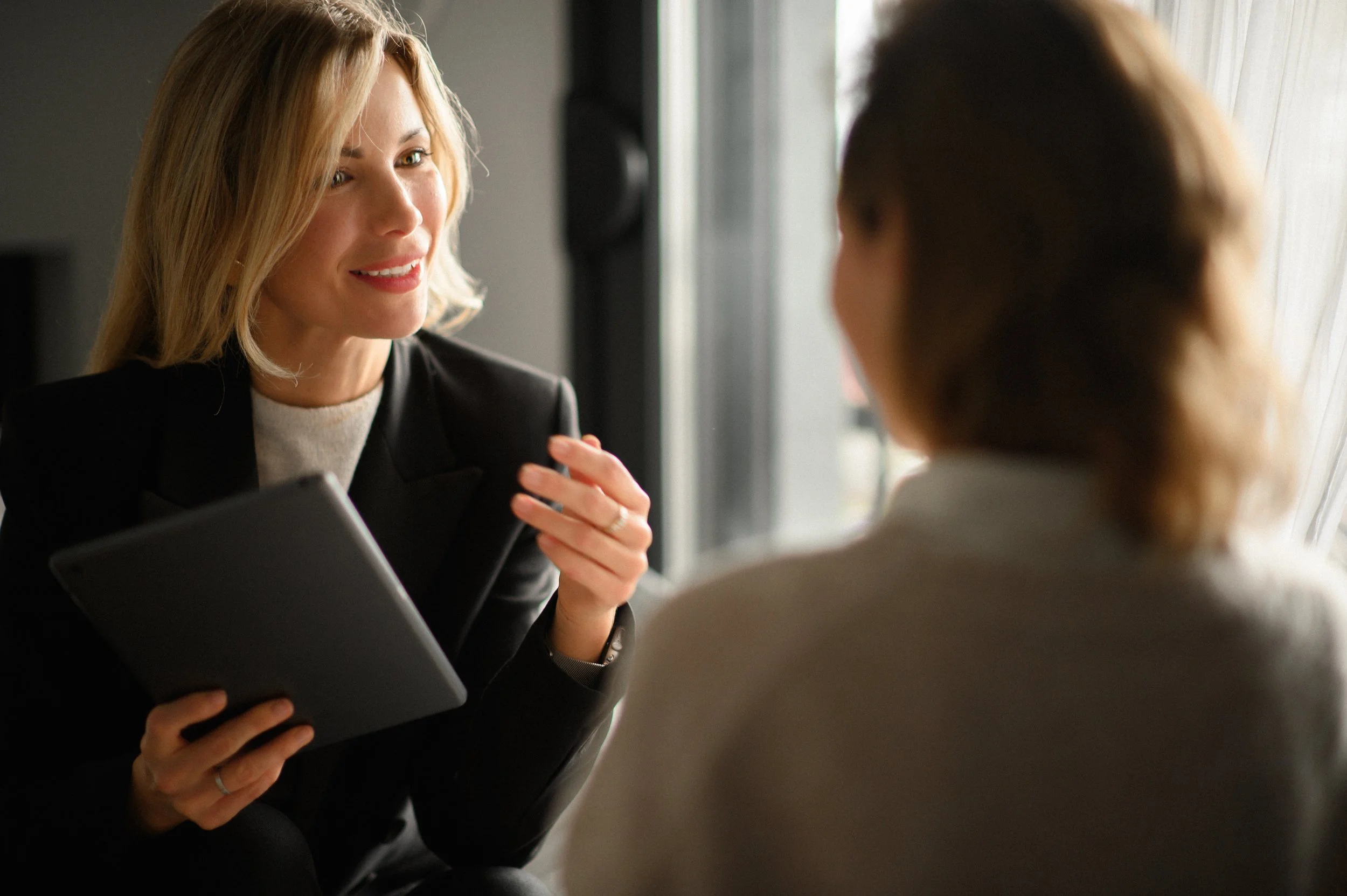 two women in business attire having a conversation