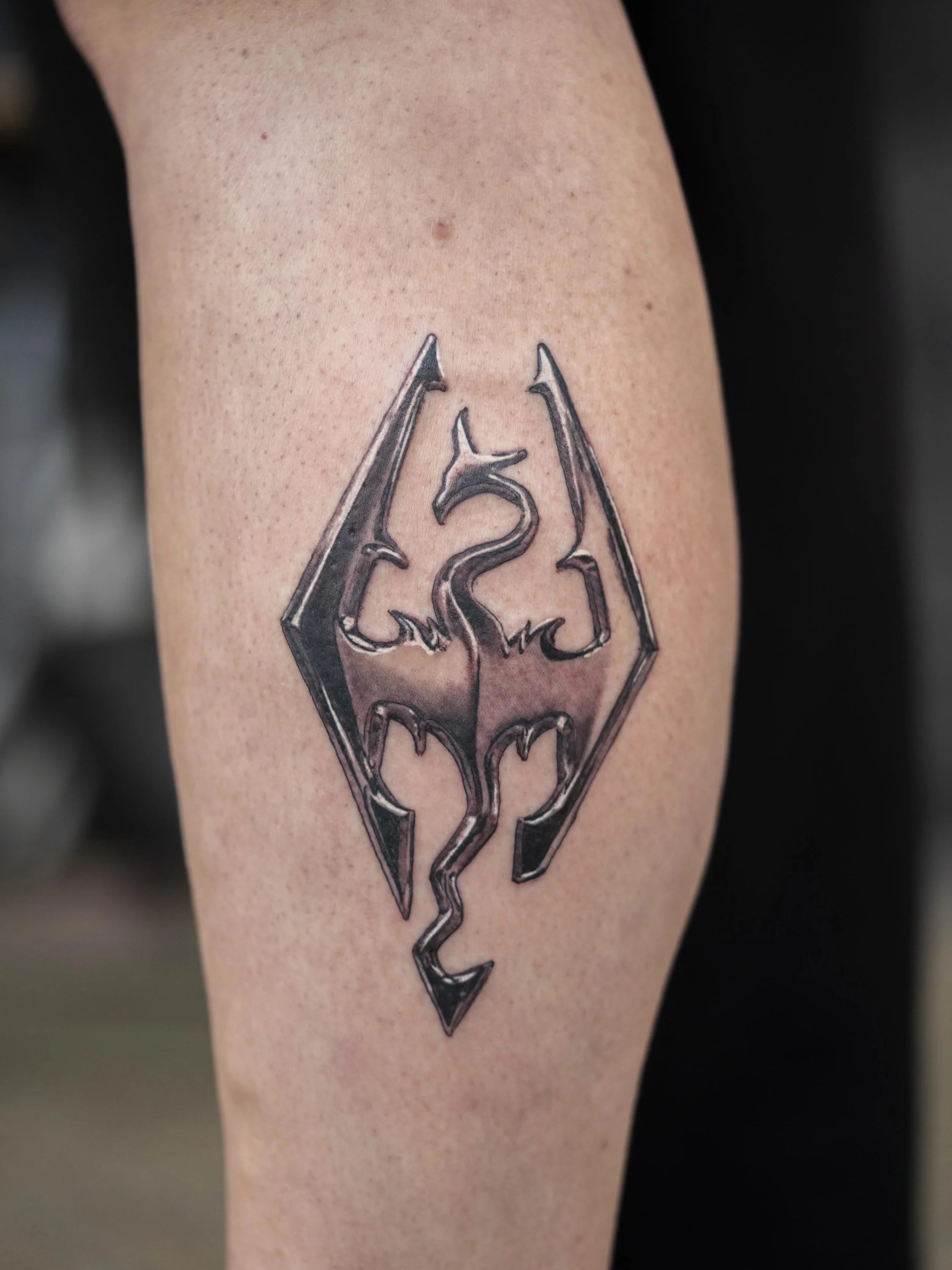 Had the best time doing this metallic Skyrim logo during my guest spot with the homies @smbtattoo.
.
S/O @simonejanepiper @tom_sorn_tattoo for having me and of course my lil sidekick @hurricanedanatattoos
.
Can&rsquo;t wait to be back for another gue