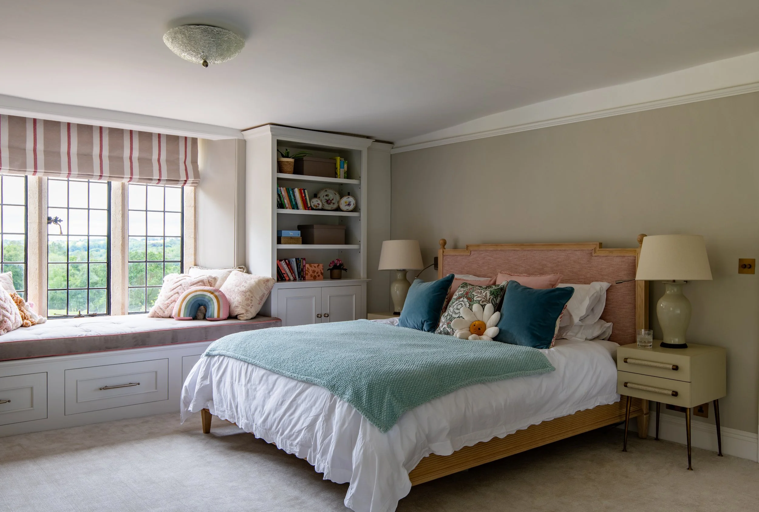 Children’s bedroom designed by MIDA Interiors for a large Cotswolds country estate, featuring a reconfigured layout, upholstered bed, full-height bespoke joinery and layered lighting that creates a calm, private sanctuary.