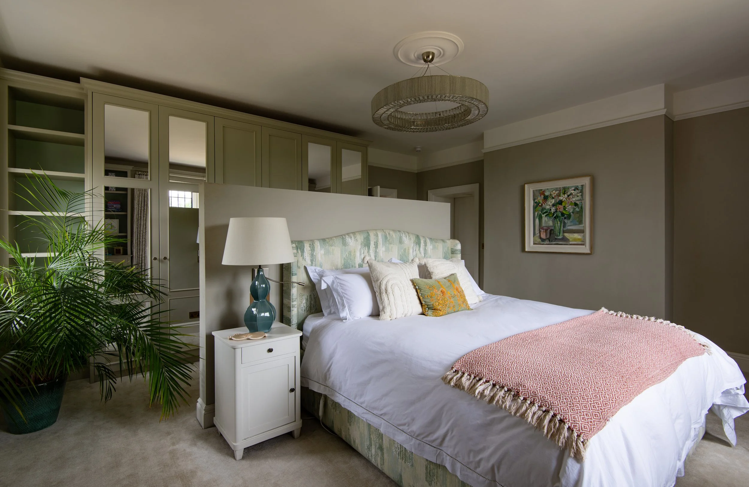Children’s bedroom designed by MIDA Interiors for a large Cotswolds country estate, featuring a half-height wall anchoring the upholstered bed, bespoke joinery, layered lighting and a calm scheme created for rest, study and play.