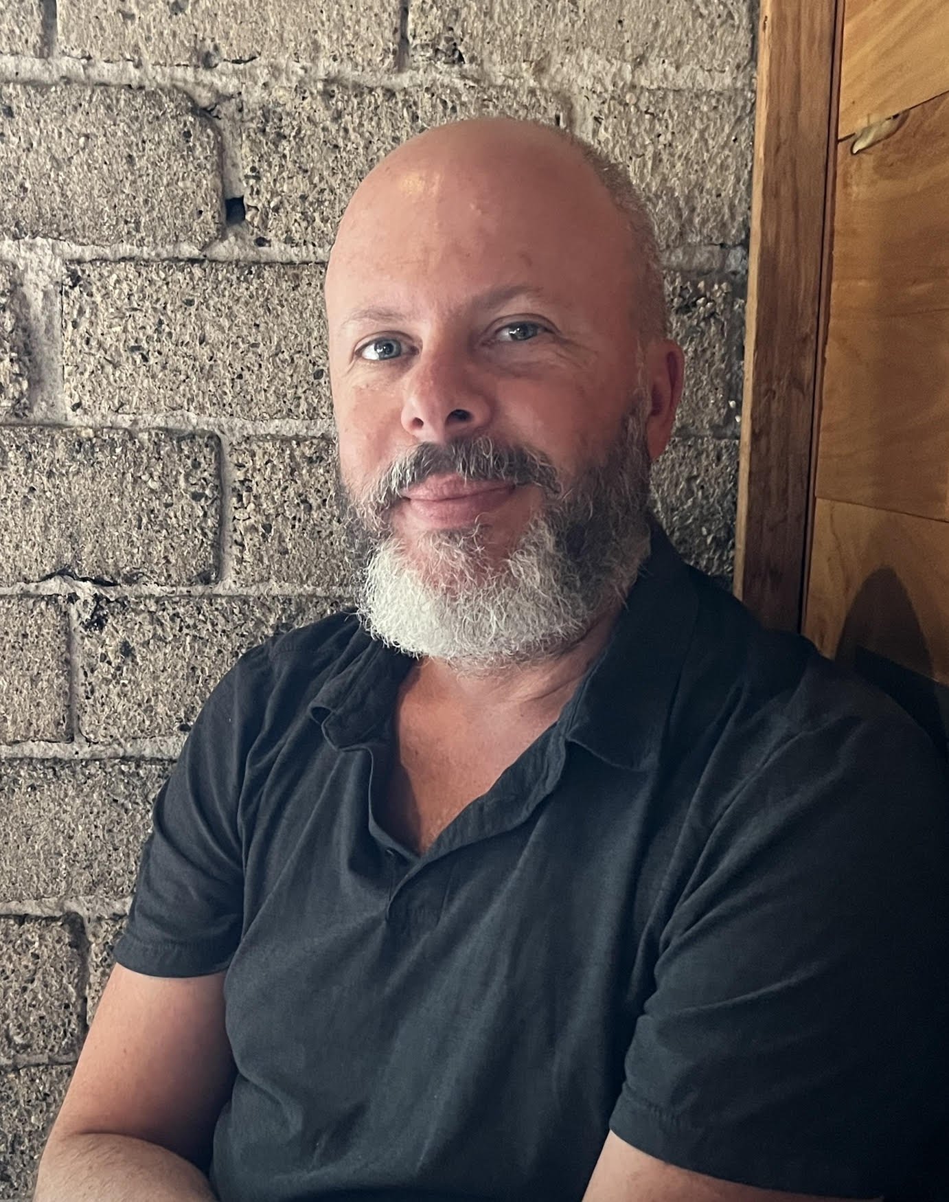 Jeff Tabnick is a light-skinned man who is in his 50s. He has gray facial hair and hair with blue eyes. He is wearing a dark polo shirt.