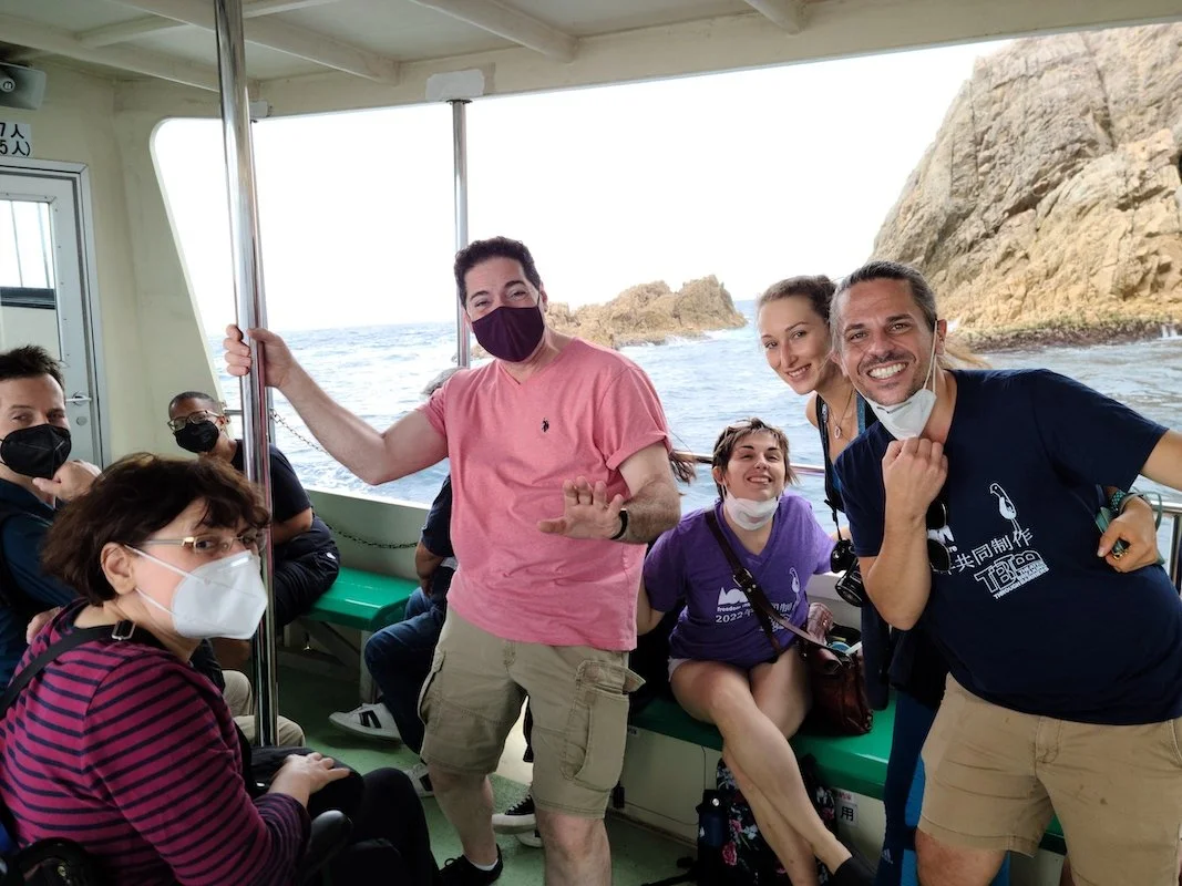 An image of 5 people, people sitting and people standing.