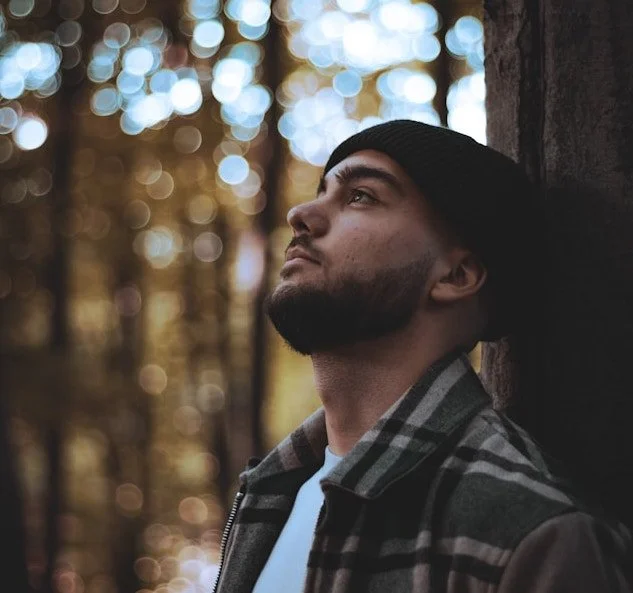 a man with a plaid shirt and beenie looking up