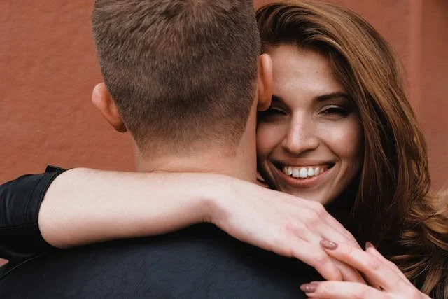 a woman smiling hugging her partner