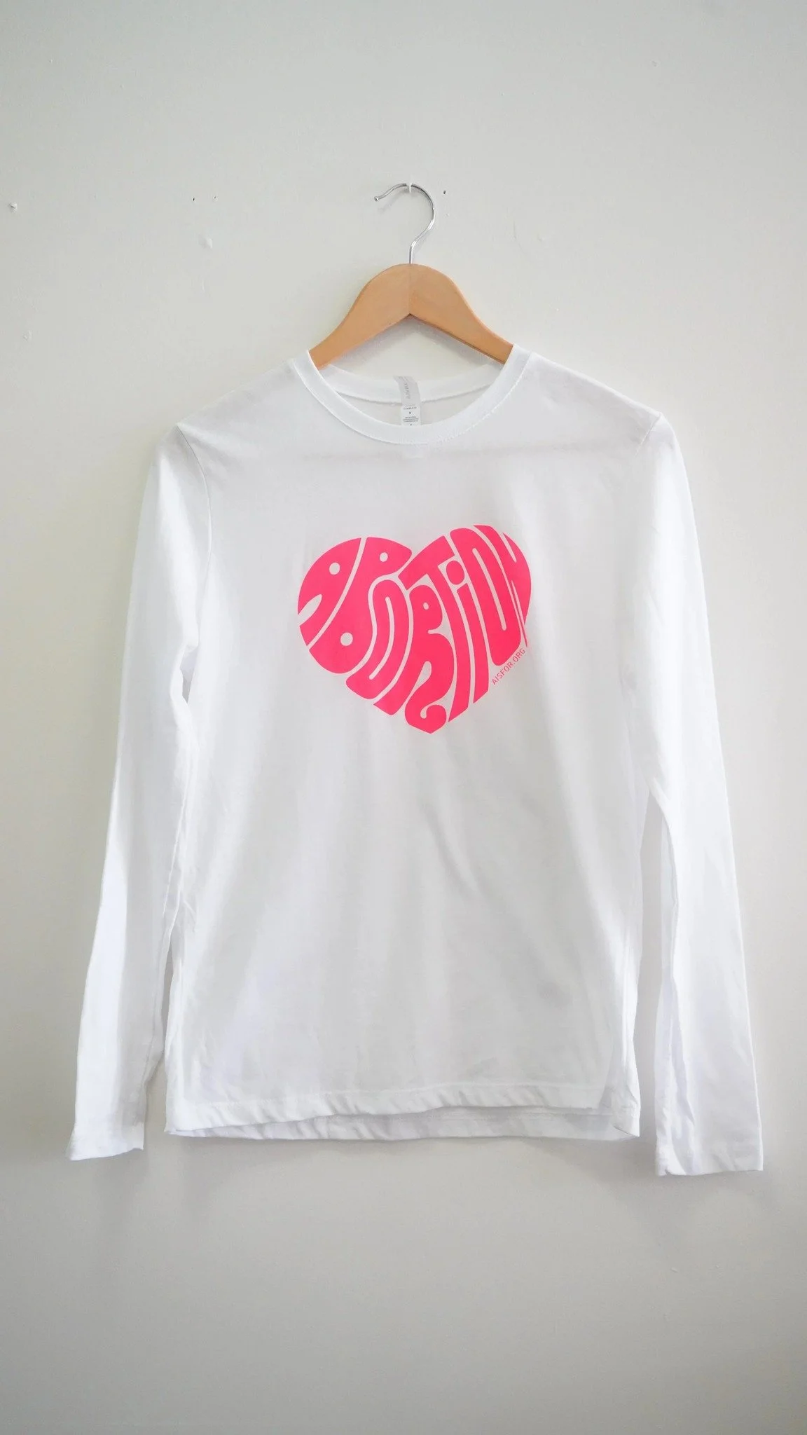 Wear your heart on your (long) sleeve with our signature Abortion Heart long sleeve, featuring artwork by @melindabeckart . Available on our website!

#nonprofit #aisfor #merch #activismwear #reprorightsshirt