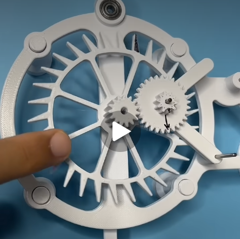 A finger points at some gears
