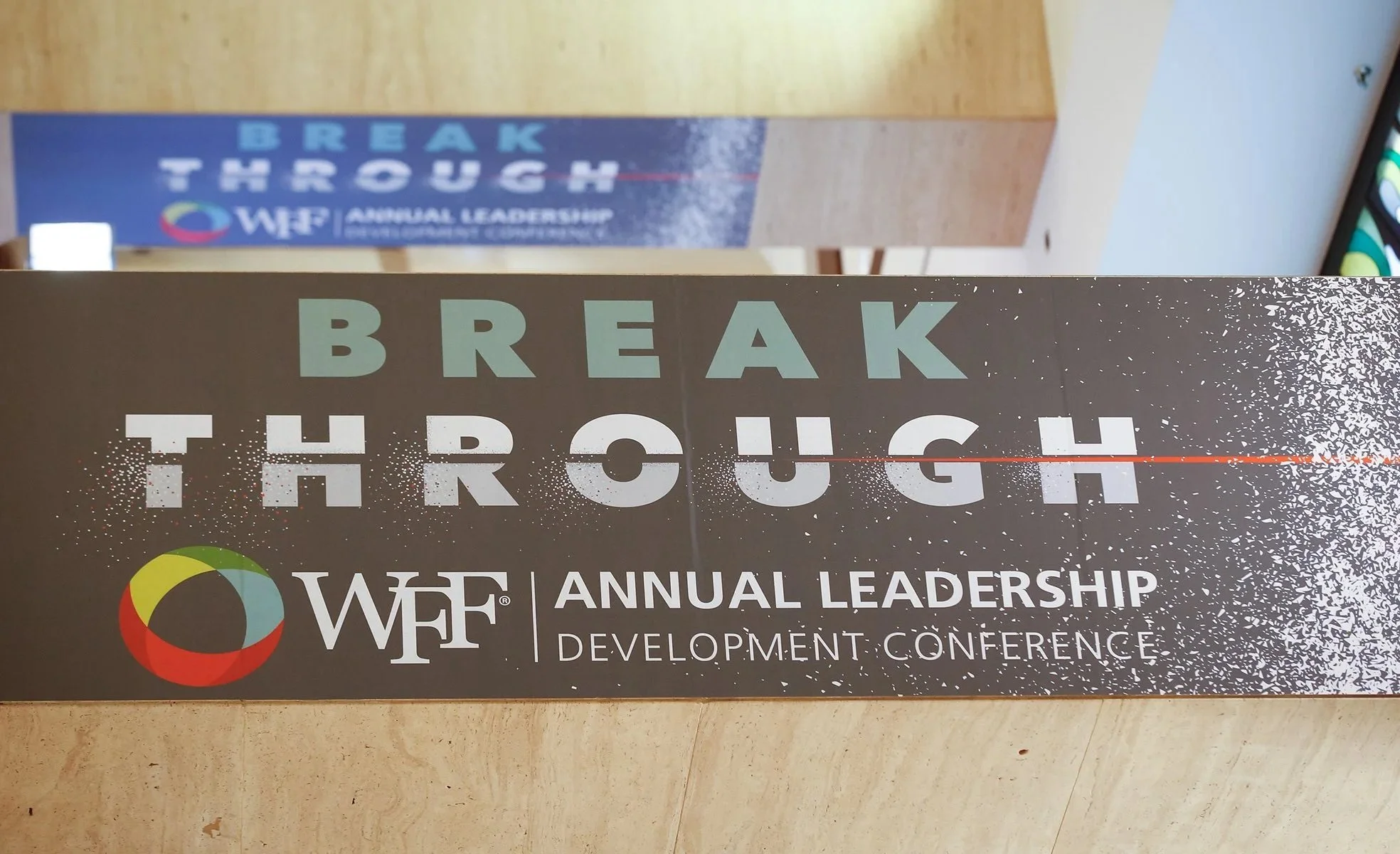 Conference badge with the text "Break Through" and event information for the 44th Annual Leadership Development Conference, including the WIF logo and design elements.