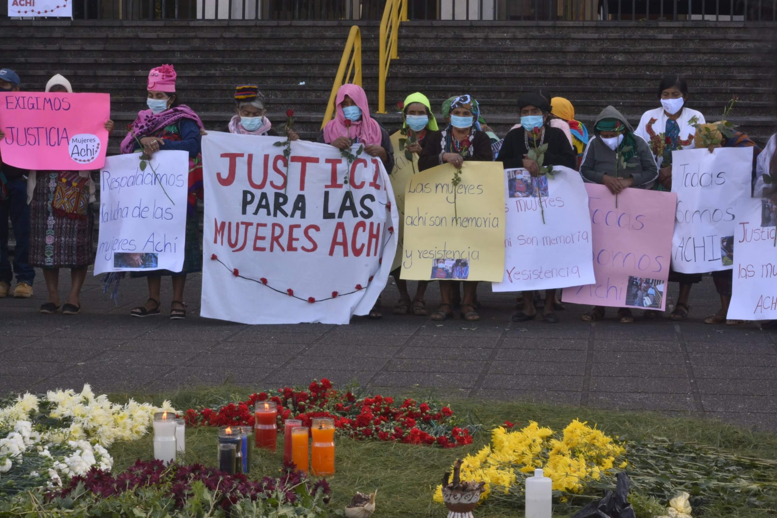  Con carteles y rosas rojas, varias mujeres indígenas transmiten  mensajes de apoyo para las 36 mujeres Achi, quienes empezaron el camino  de la justicia contra los cinco expatrulleros desde 2011.  