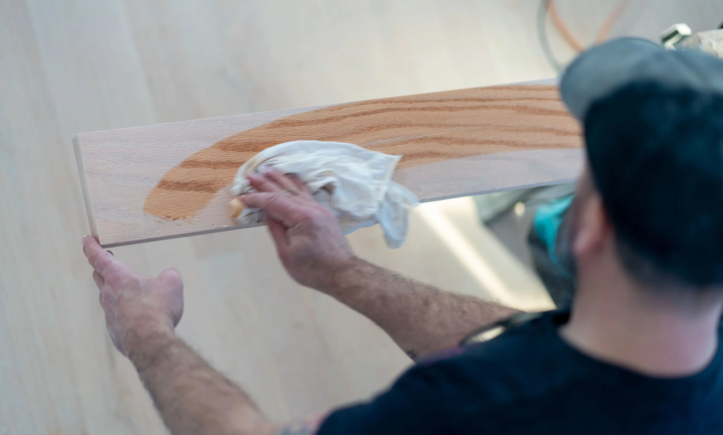 Person cleaning a wooden board with a cloth.