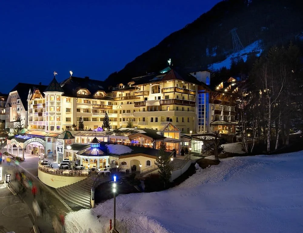 Façade illuminée de l’Hotel Post Ischgl 4 étoiles en Autriche, au cœur de la station, idéale pour un séminaire d’entreprise Aylo Montagne.