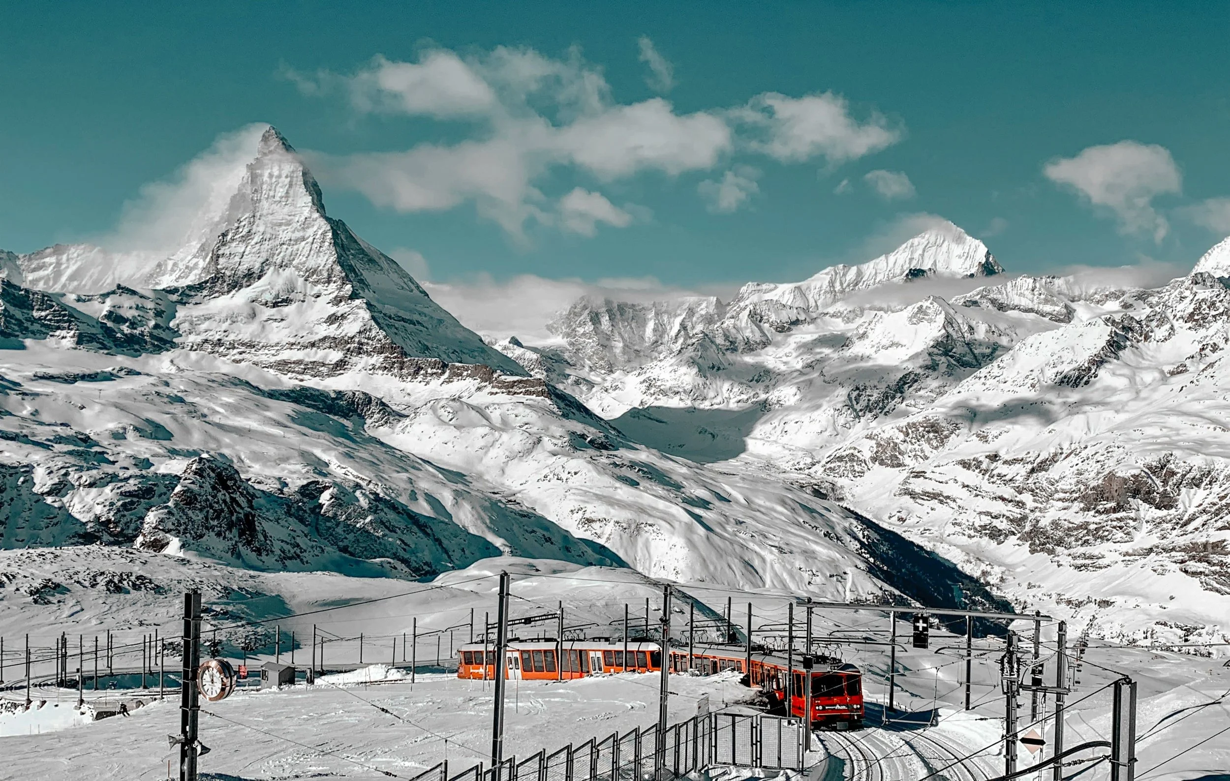 Train panoramique rouge du Gornergrat traversant les paysages enneigés de Zermatt avec vue sur les sommets alpins et le Cervin.