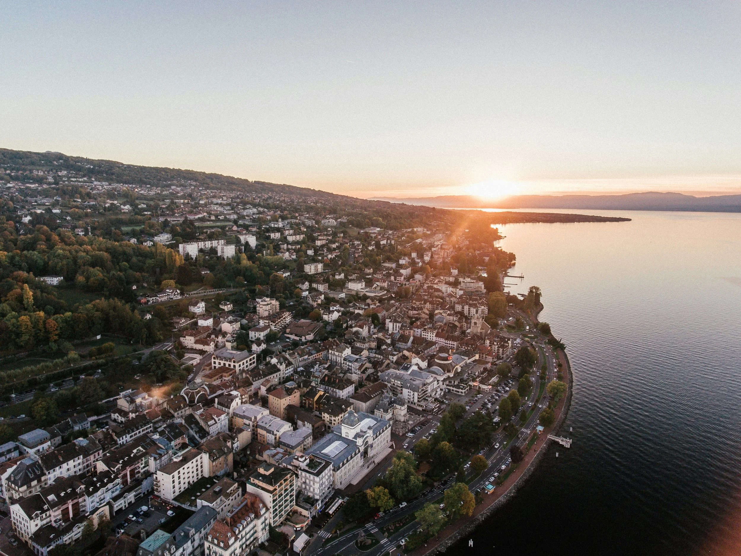 Vue aérienne d’Évian-les-Bains au coucher du soleil – architecture, lac Léman et panorama alpin – Aylo Montagne.