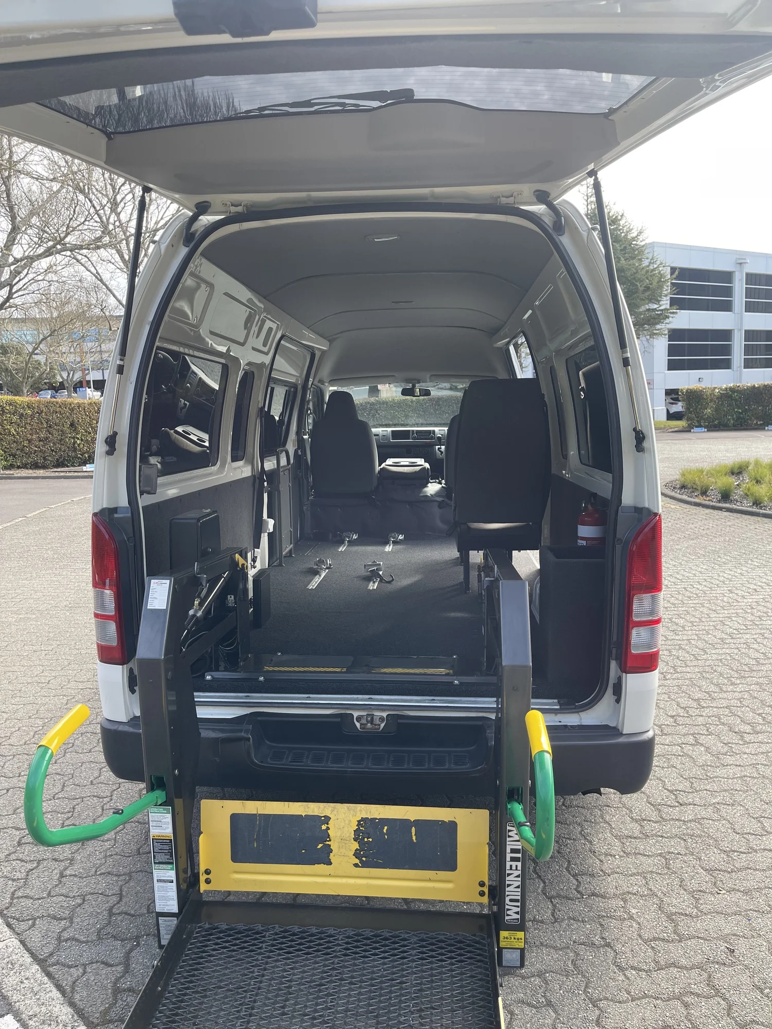 Toyota Hiace with rear doors open, showing the powered hoist platform