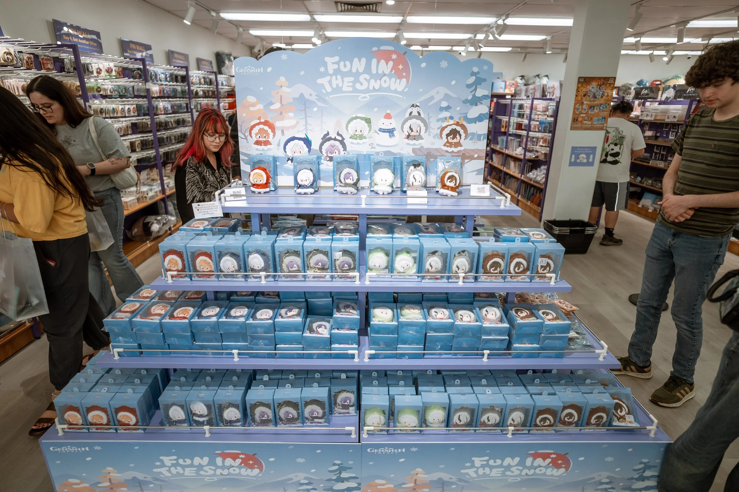Display of plush toys themed around snow and winter, with a colorful sign reading 'Fun in the Snow,' inside a retail store.
