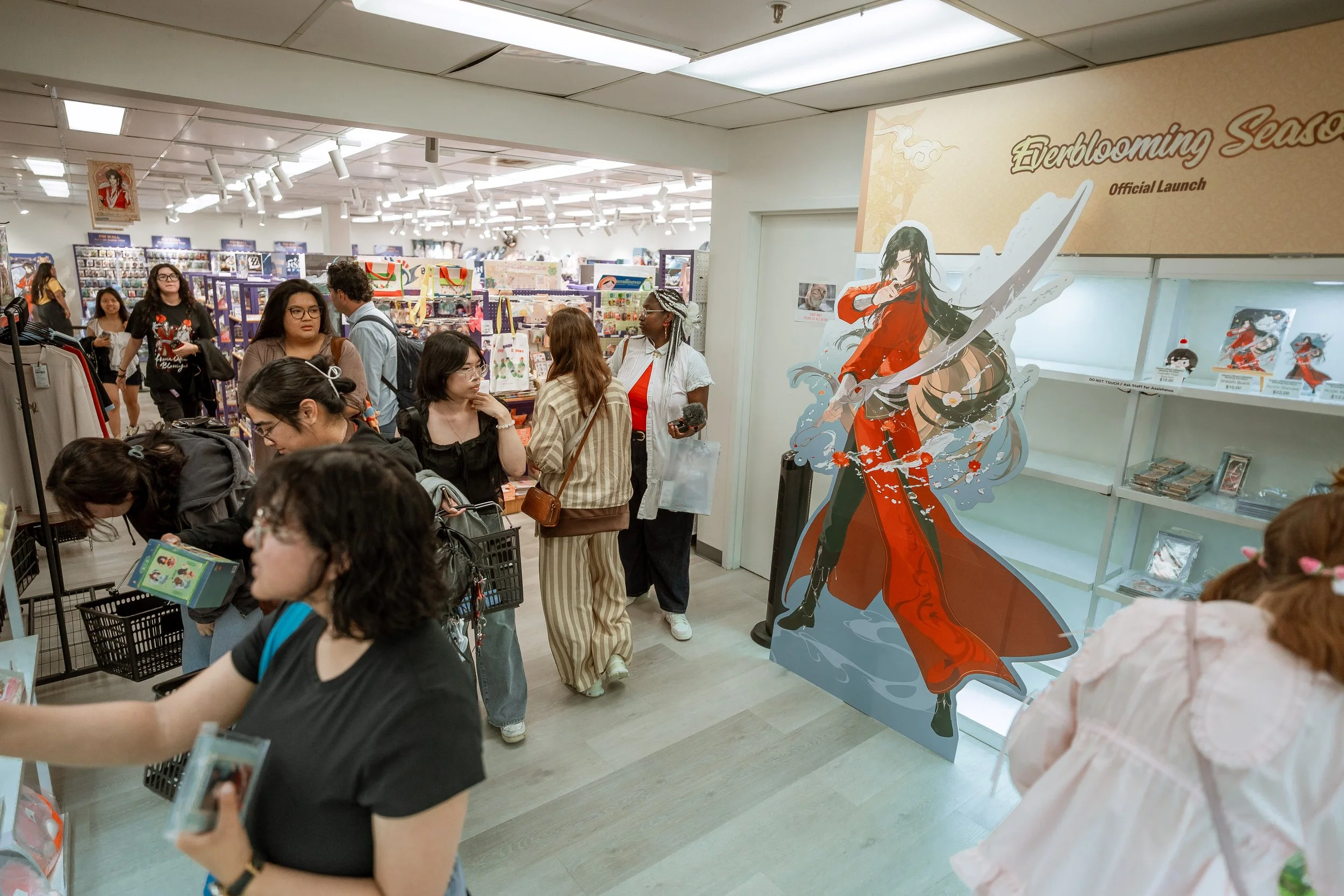 People shopping in a bookstore with a promotional display for 'Everdreaming Season' at its official launch, featuring an anime-style character illustration.