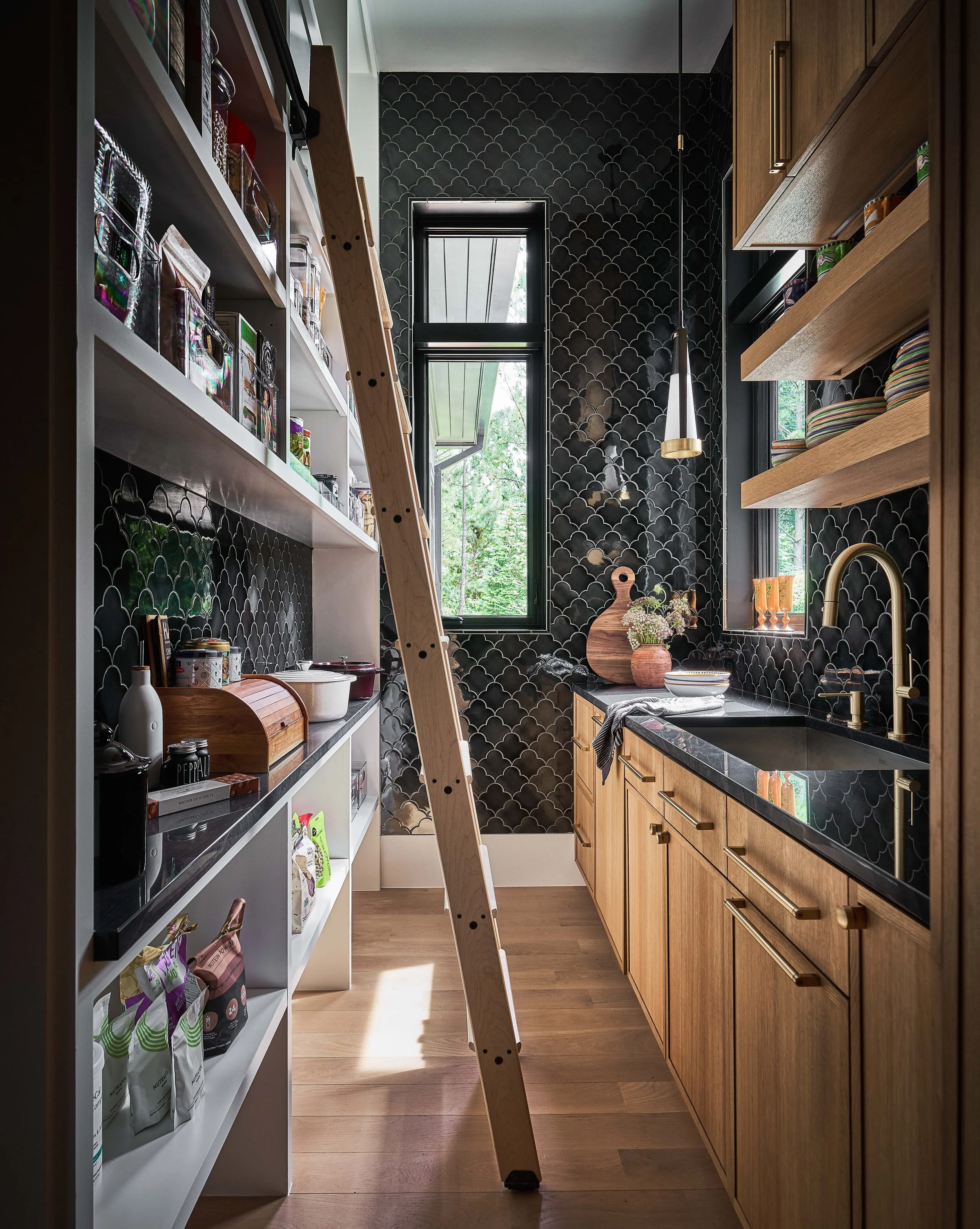 scullery kitchen design with floor to ceiling tile black quartzite countertop open shelving custom cabinetry hidden panty with sliding library ladder luxury custom home durham nc durham interior designer custom home interior designer