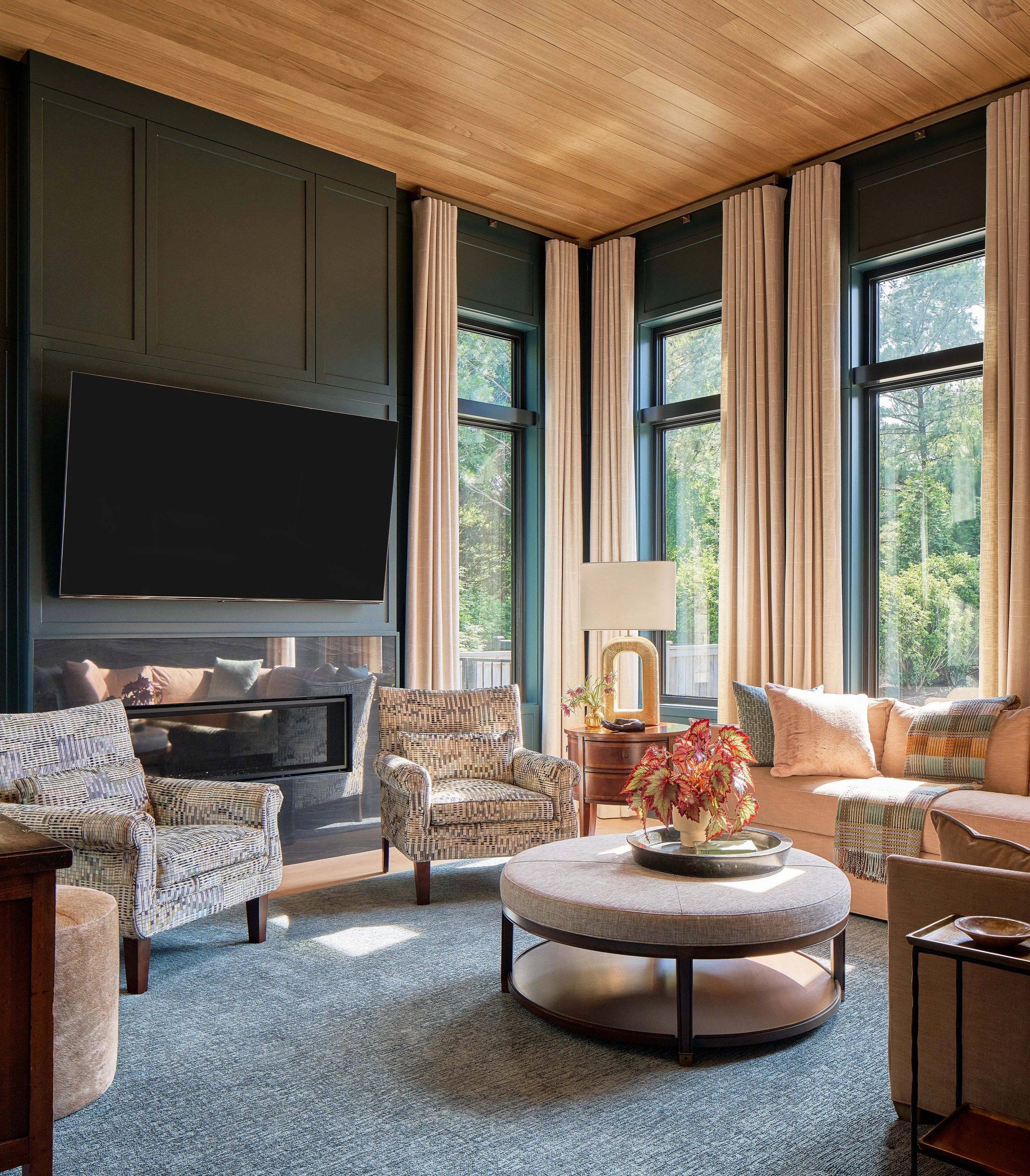 large family room den with inlaid wood ceiling inset carpet black quartzite fireplace surround floor to ceiling wainscoting dark blue walls custom home interior designer durham interior designer luxury interior design firm chapel hill north carolina