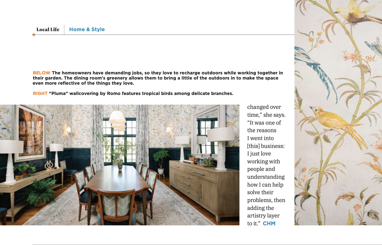 excerpt from feature in chapel hill magazine about cat french design's dining room design showing wood dining room table with upholstered chairs patterned drapery dark blue wainscoting and bird patterned wallpaperg