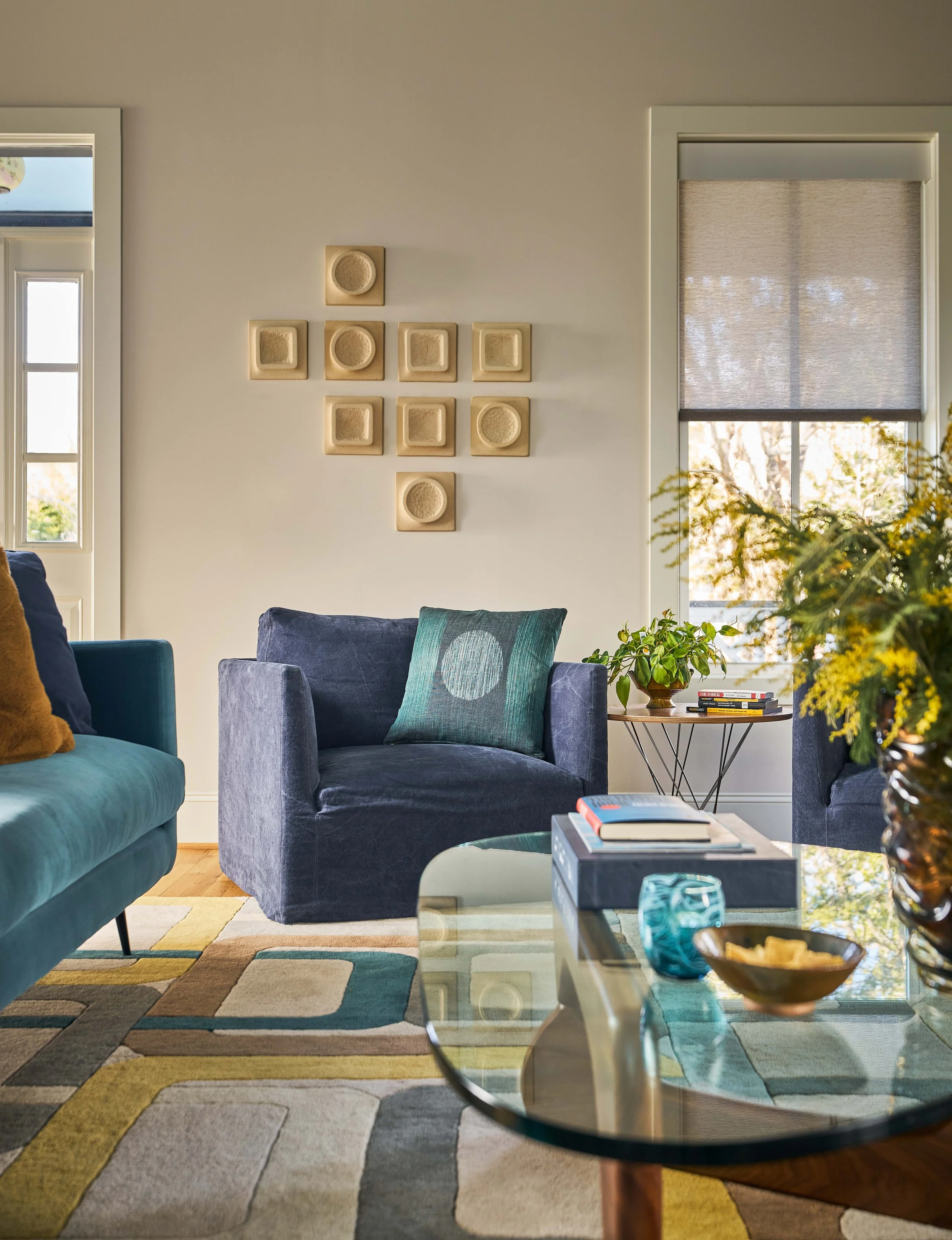 plush blue armchairs and sofa with modern glass coffee table colorful mid-century modern home design by cat french design colorful interior designer comfortable luxury interior design soulful interiors chapel hill interior designer