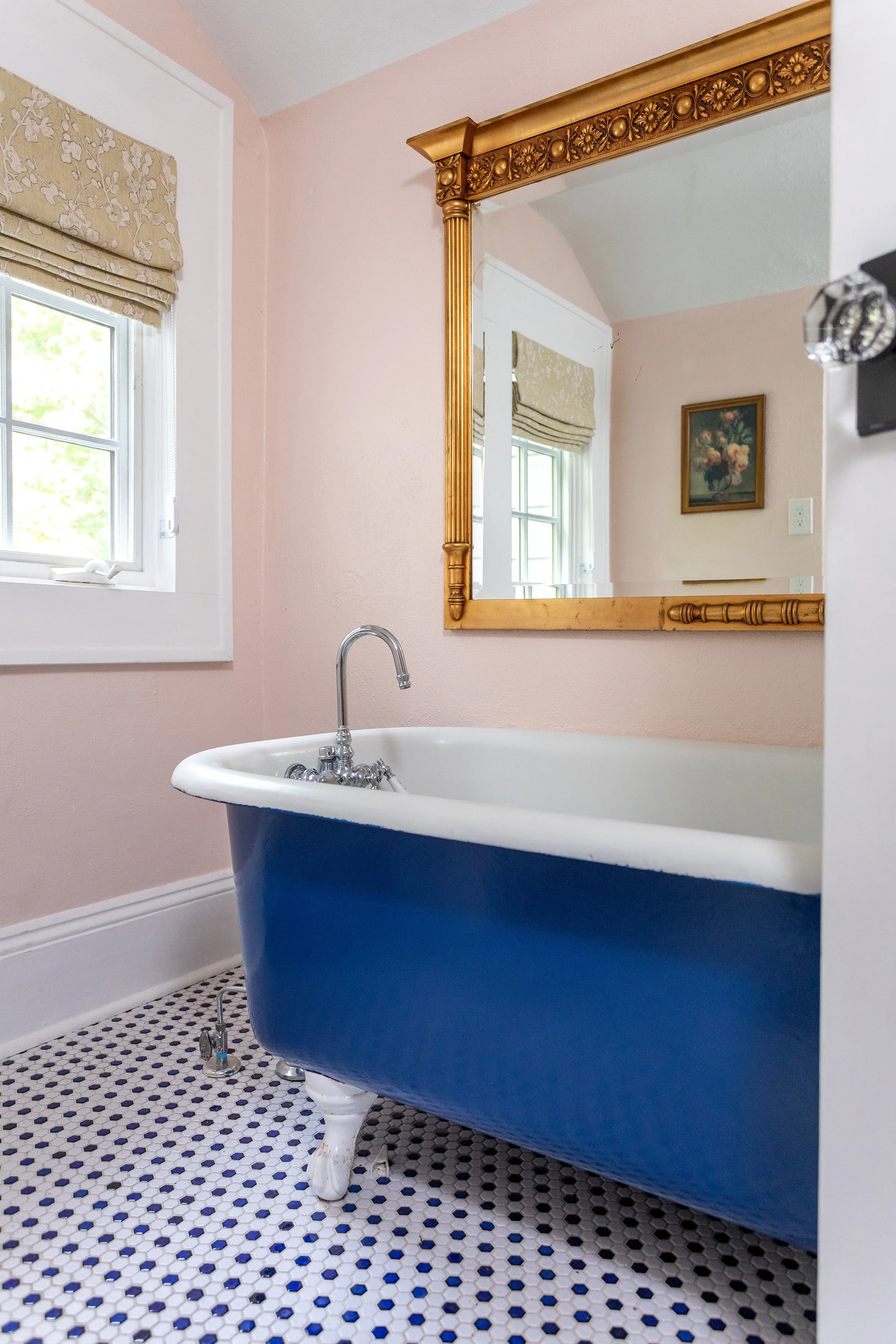 bathroom with vivid blue claw foot tub hex floor tile and large gold mirror in a historic chapel hill home designed by cat french design durham interior designer award winning chapel hill interior designer