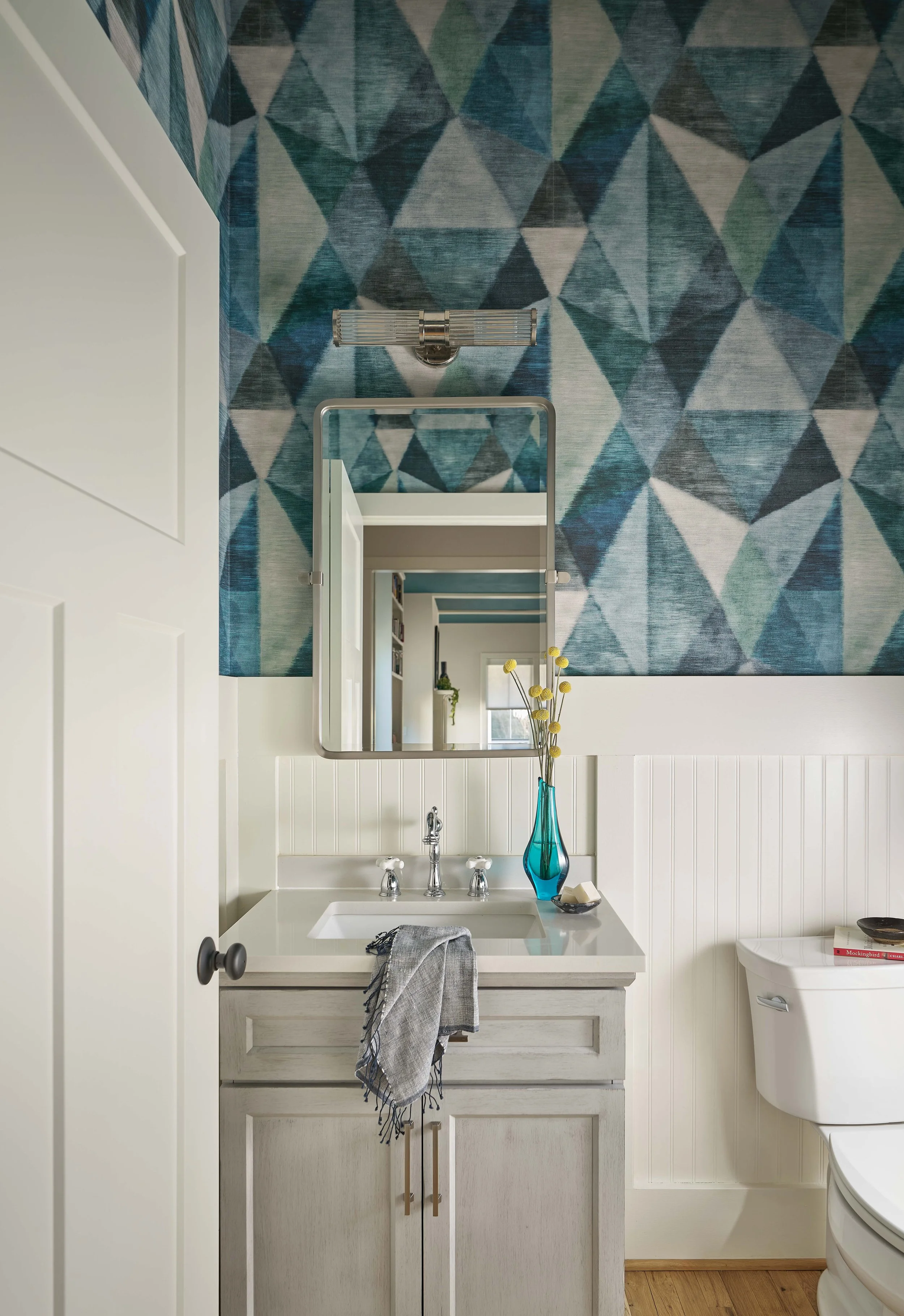 powder room design with blue and white geometric wallpaper and light gray vanity in mid-century modern home design chapel hill interior designer cat french design comfortable luxury interior design