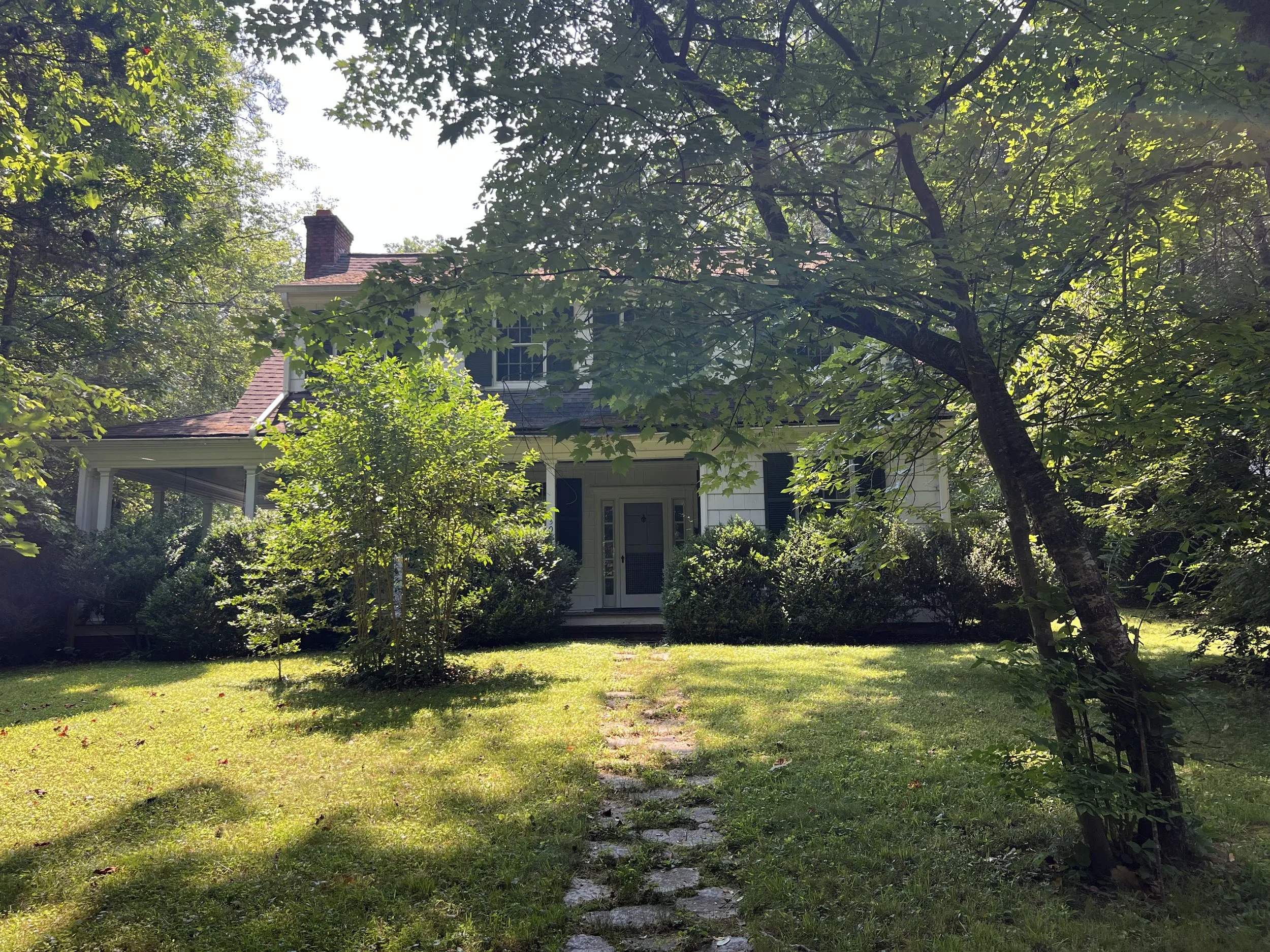 a white historic home on a wooded lot in chapel hill nc renovated by cat french design chapel hill interior designer
