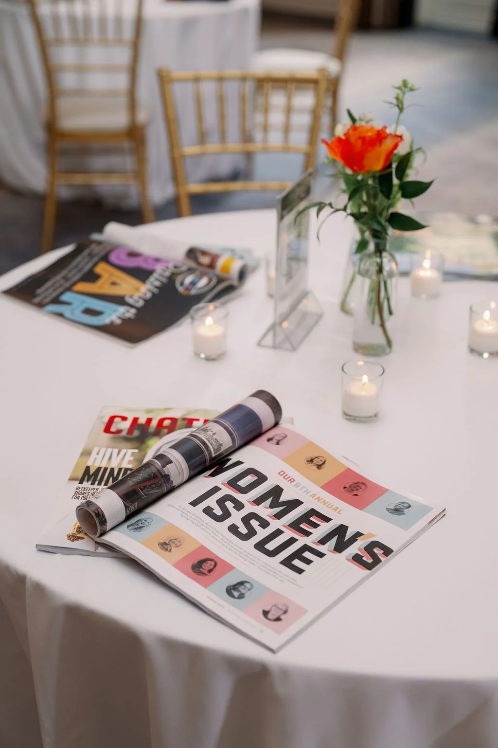 table with candles and women's issue of chapel hill magazine at women of achievement event 2025