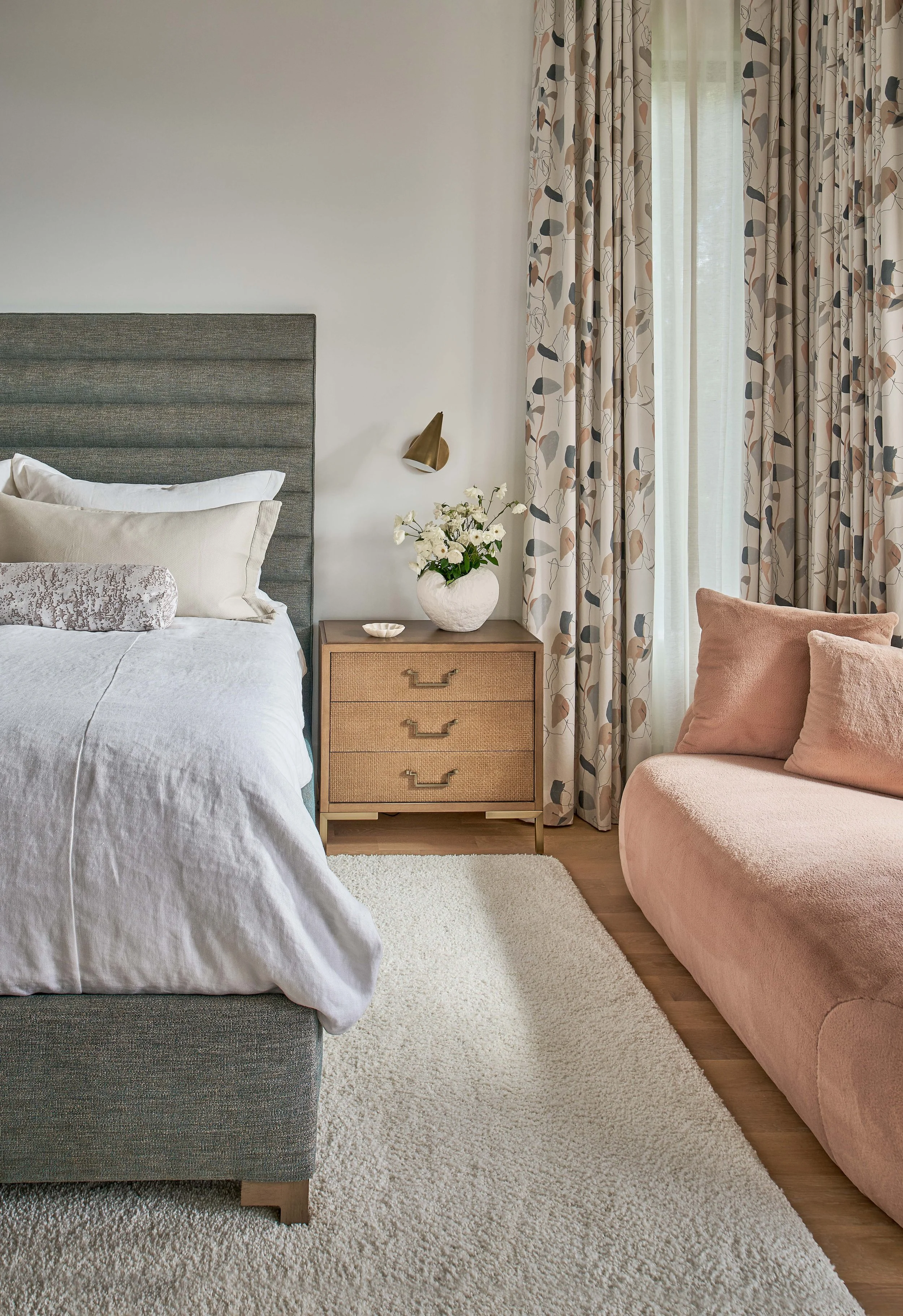 primary bedroom design with gray upholstered bed neutral curtains and plush chaise lounge chair designed by cat french design chapel hill interior designer durham interior designer luxury interior design north carolina custom home interior design nc
