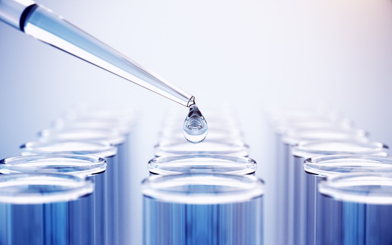 Lab worker holding lab test tray with blue liquid