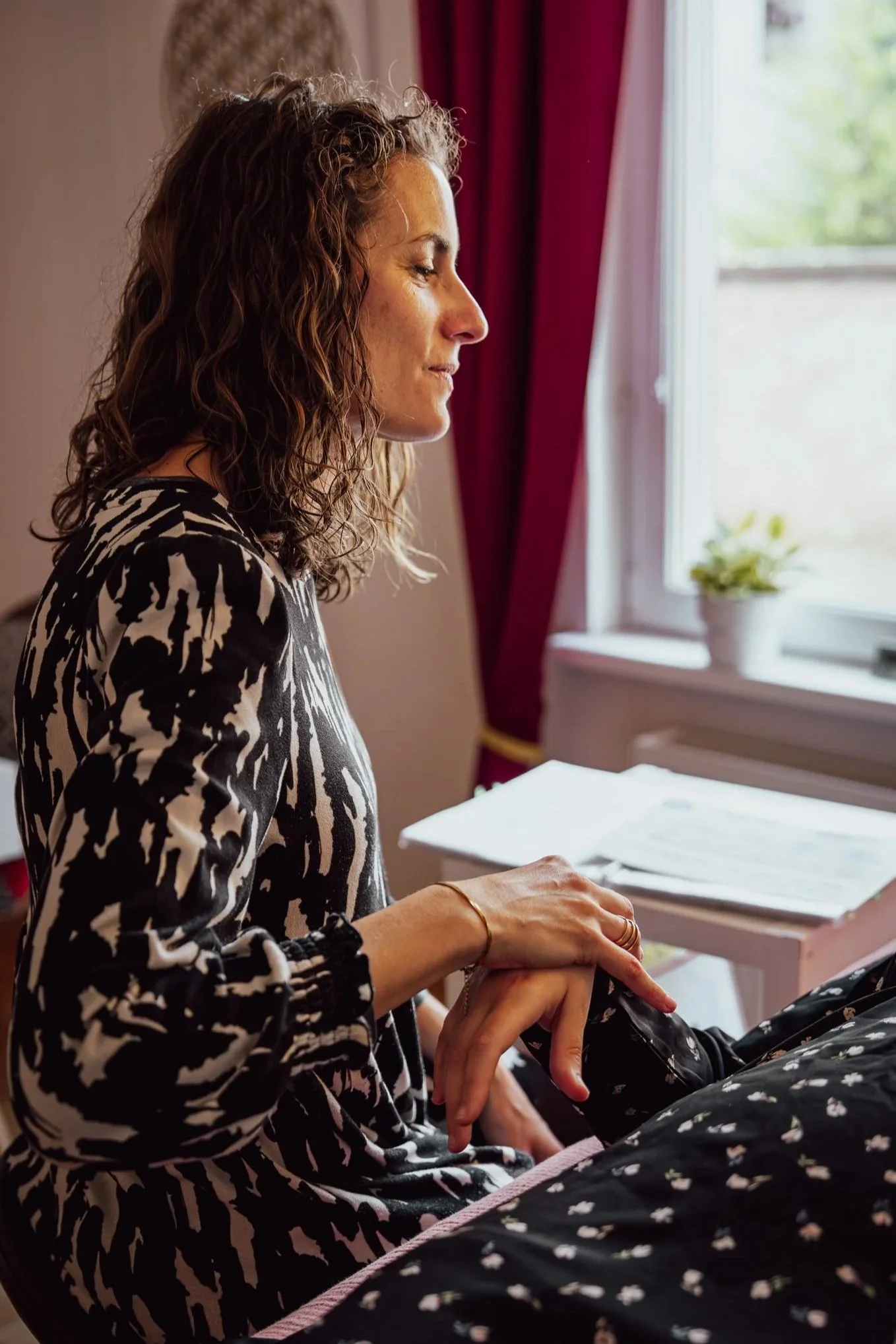 Une personne allongée sur une table de massage reçoit un test musculaire de kinésiologie, une autre personne tient son bras dans un cadre thérapeutique dans une pièce avec une ambiance calme.