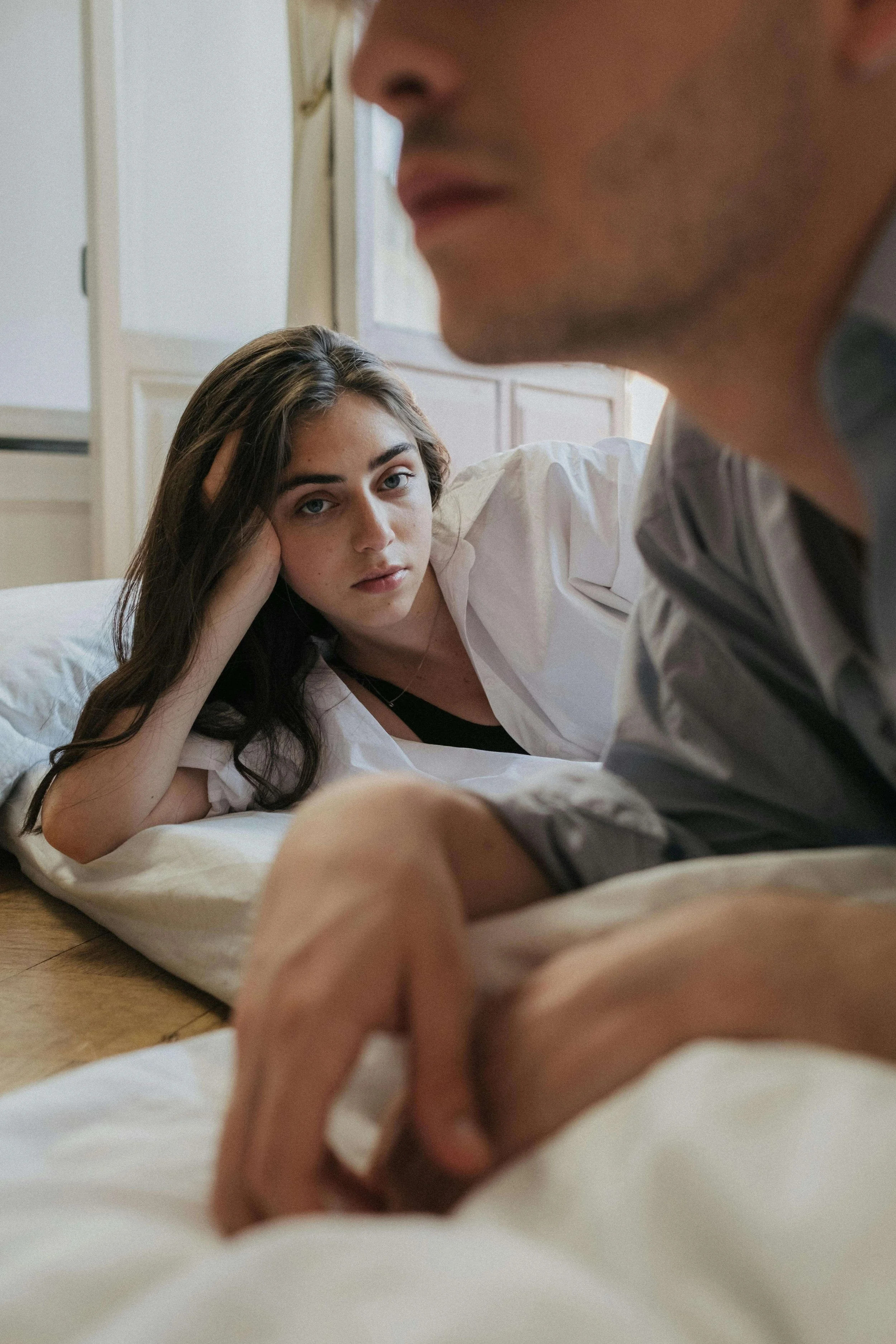 A couple lying in bed near each other