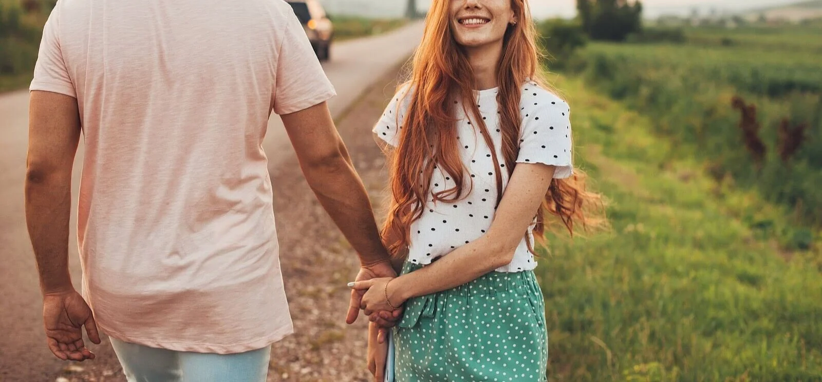 A couple walking hand in hand outside