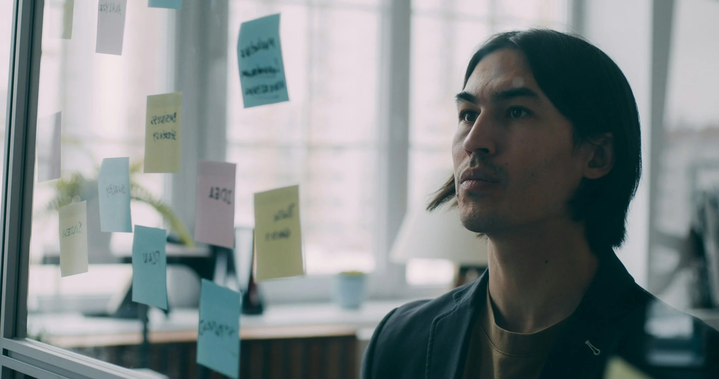 Person looks at post it notes on planning wall