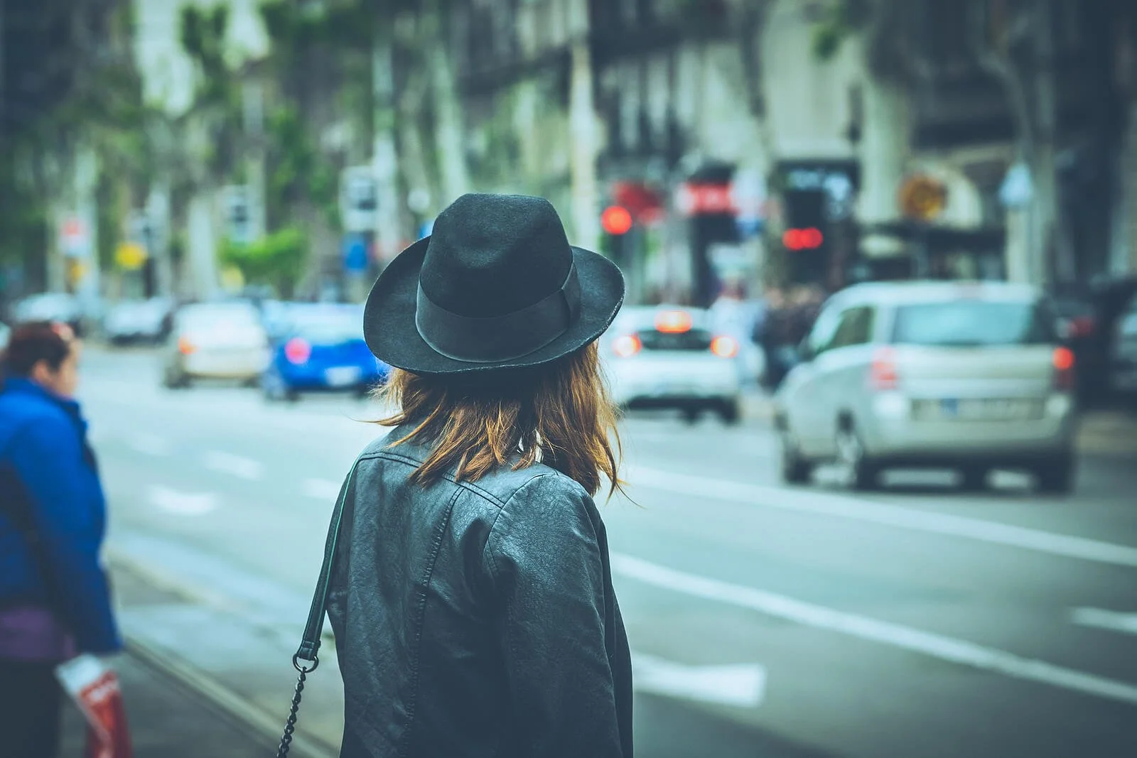 Woman wearing a hat looking away from camera on a busy New York City street